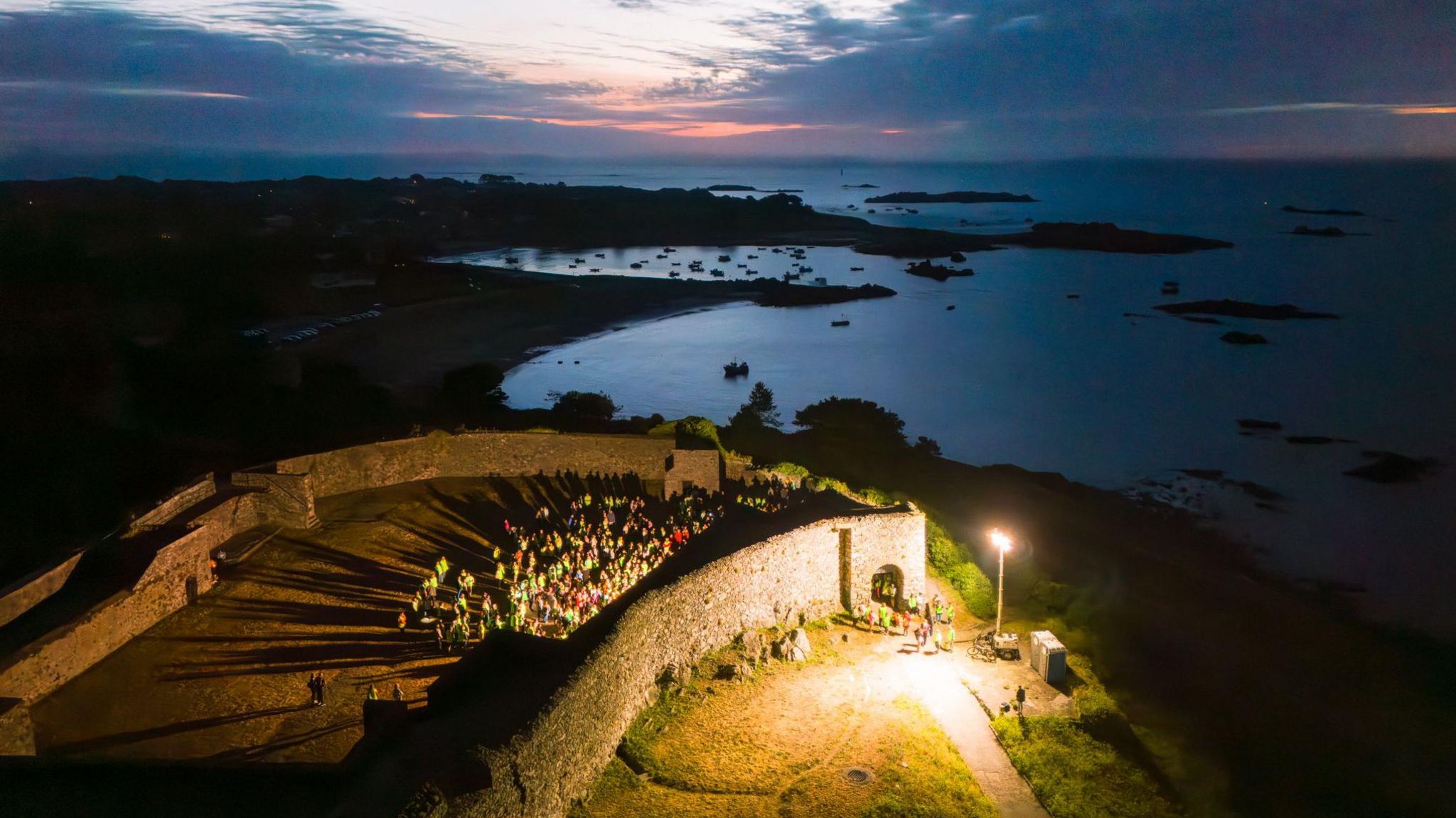 A drone photo showing people gathering at sunrise at Vale Castle