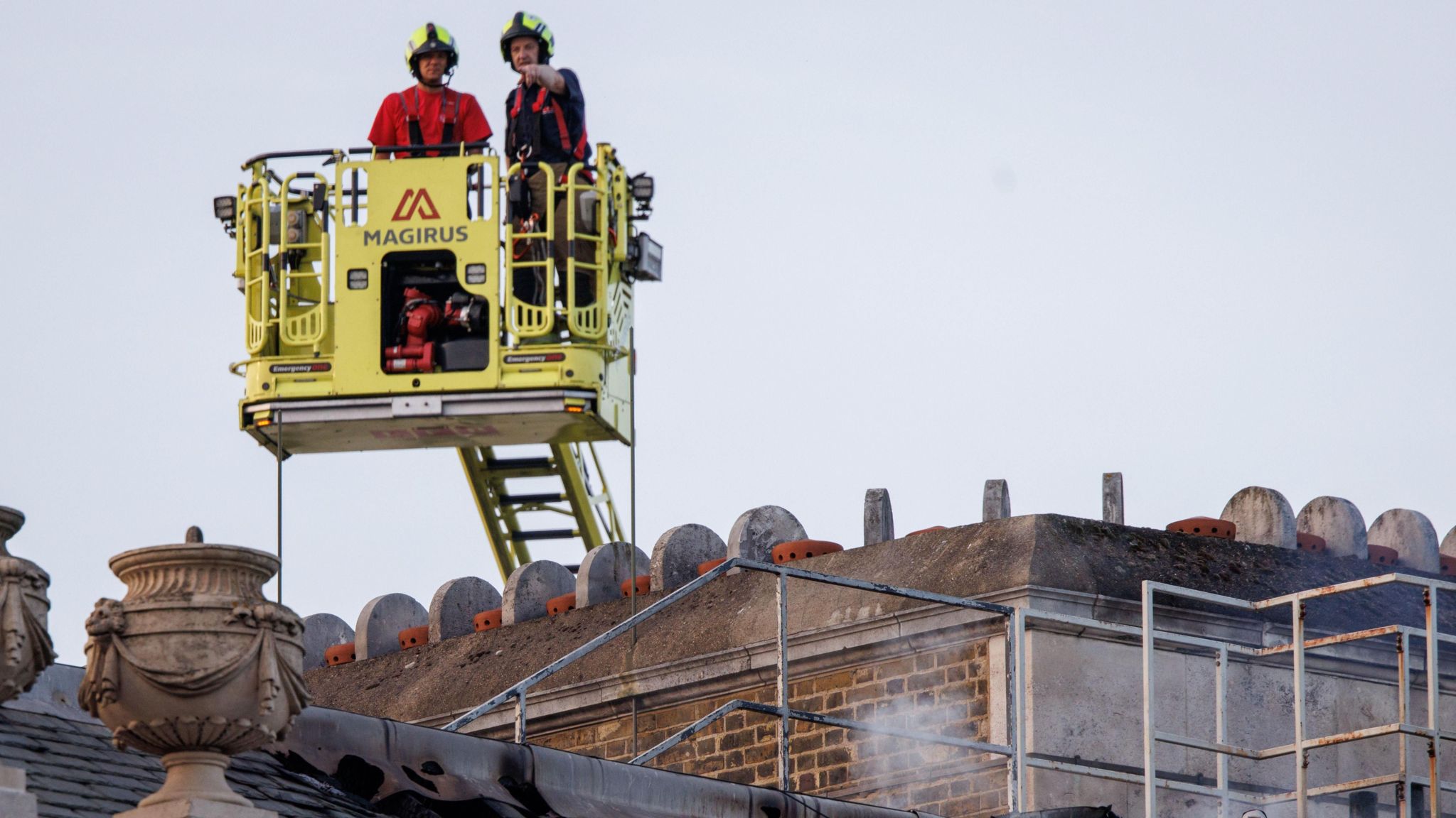 Firefighters in a aerial lift look down on the damage at Somerset House.