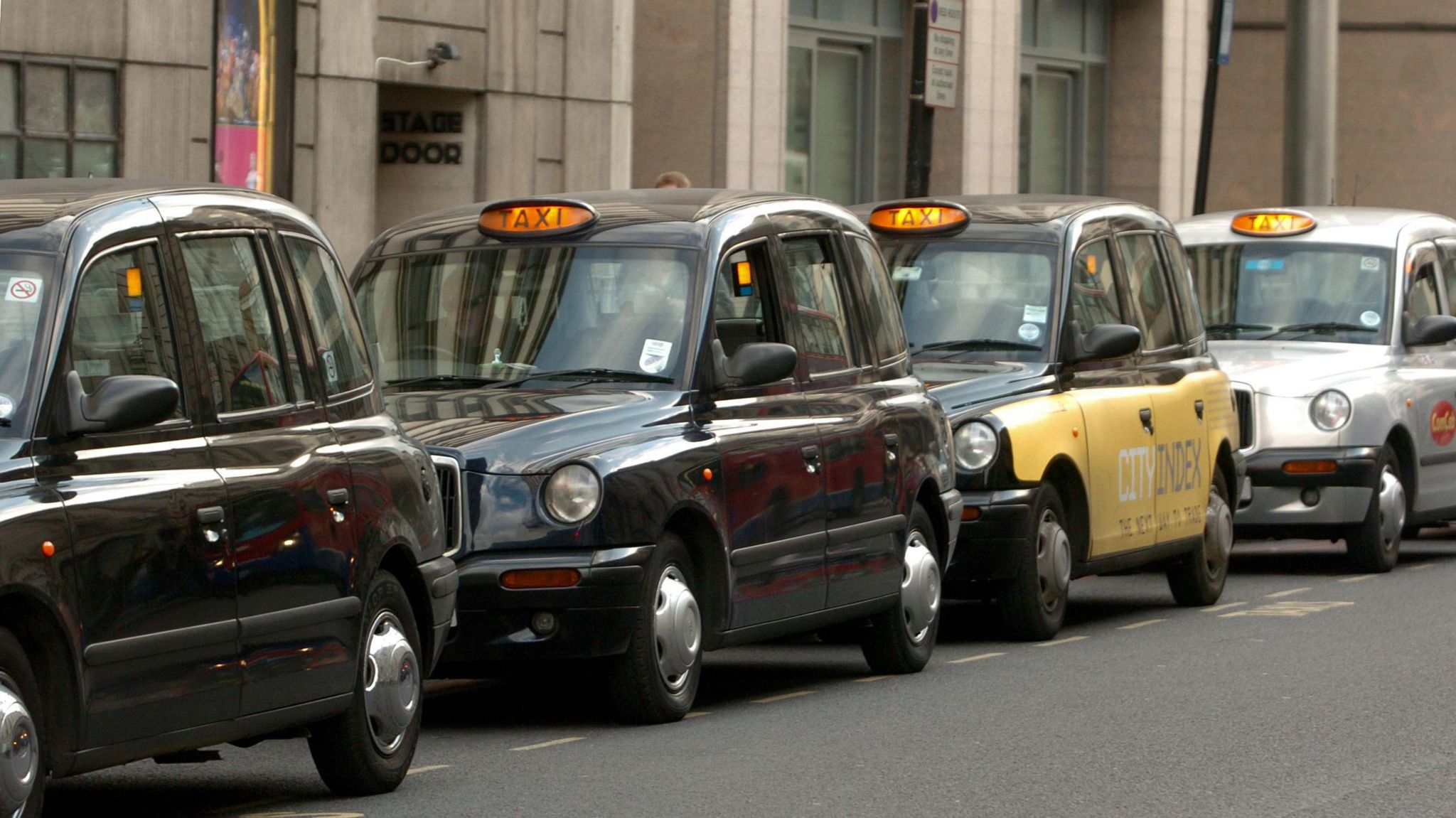 Hackney carriages or London taxis ("Black Cabs") wait on a cab rank at Victoria Station 