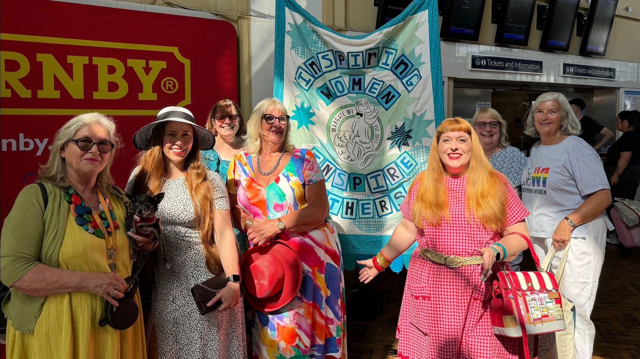 Margate Women's Institute in Margate train station holding a banner