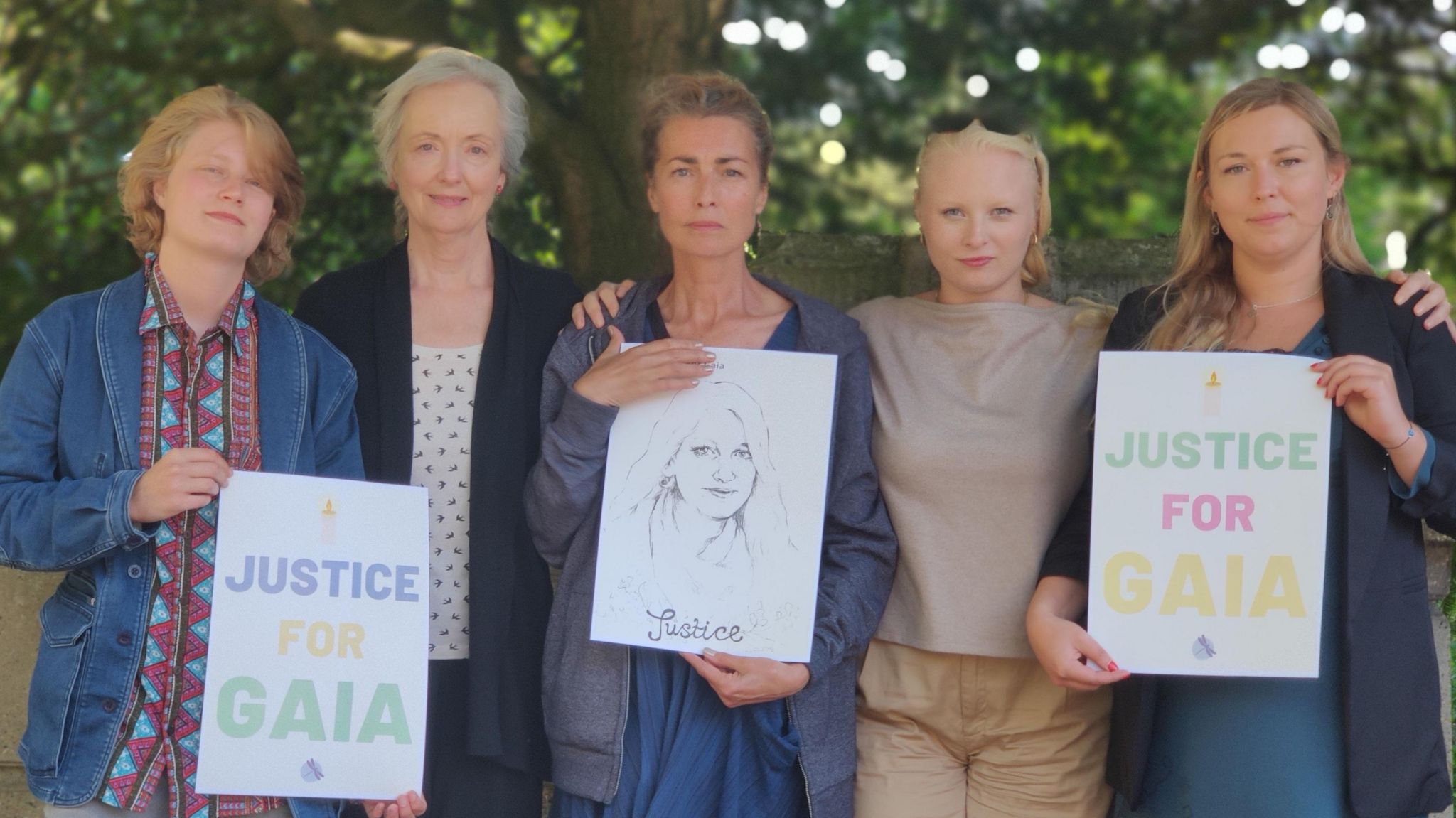 Five family members - all women - holding Justice for Gaia placards outside Gaia's inquest