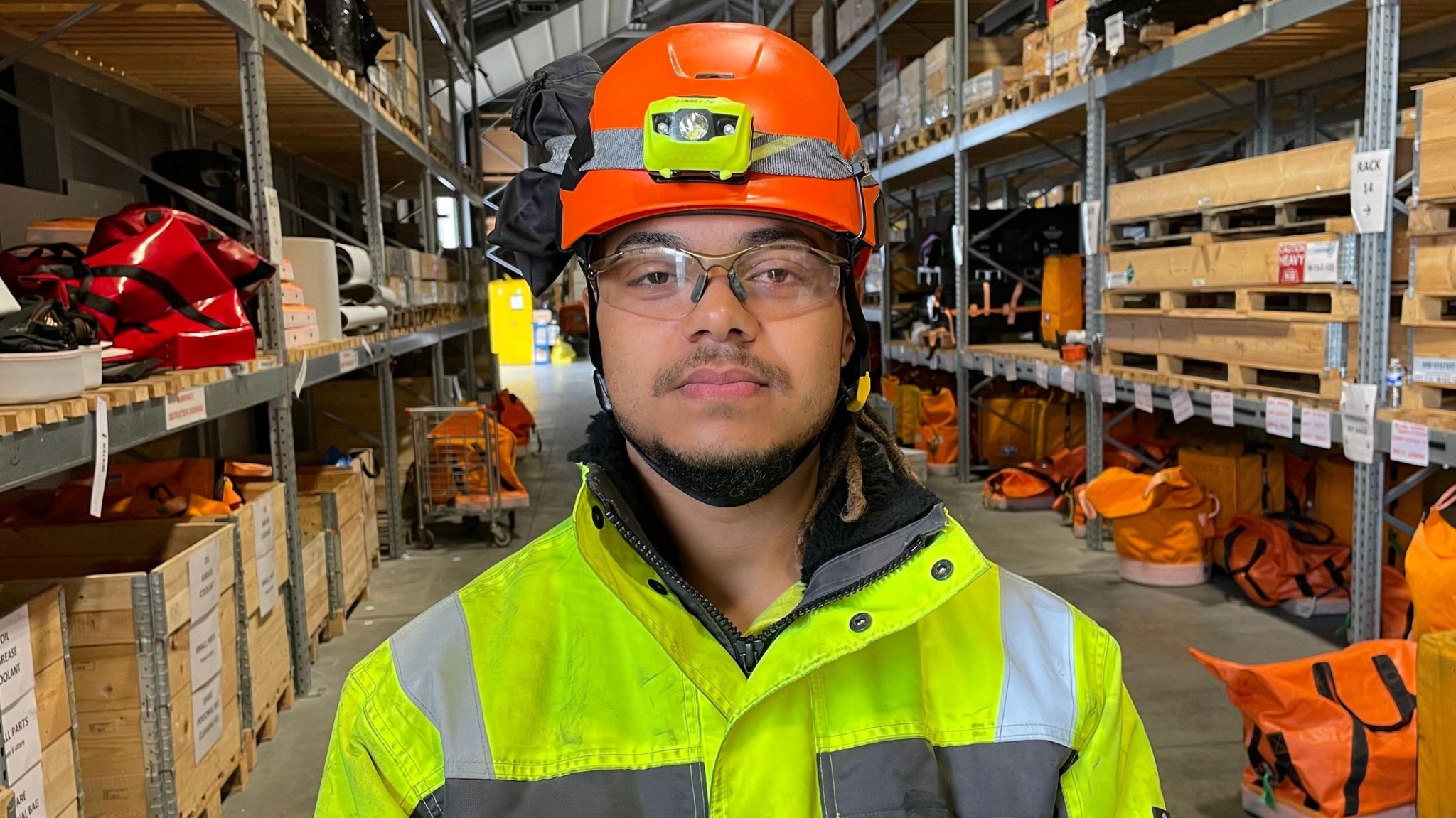 Bailey Woolston standing in a Scottish Power Renewables warehouse in the Port of Lowestoft