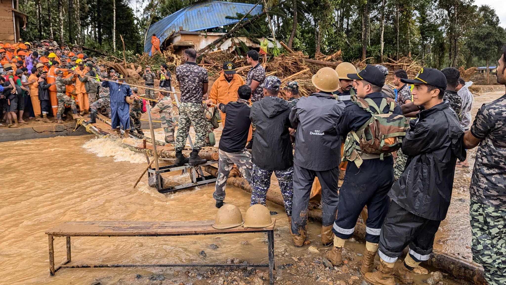 Rescue officials seen carrying out relief work at the site of the accident as a crowd watches on