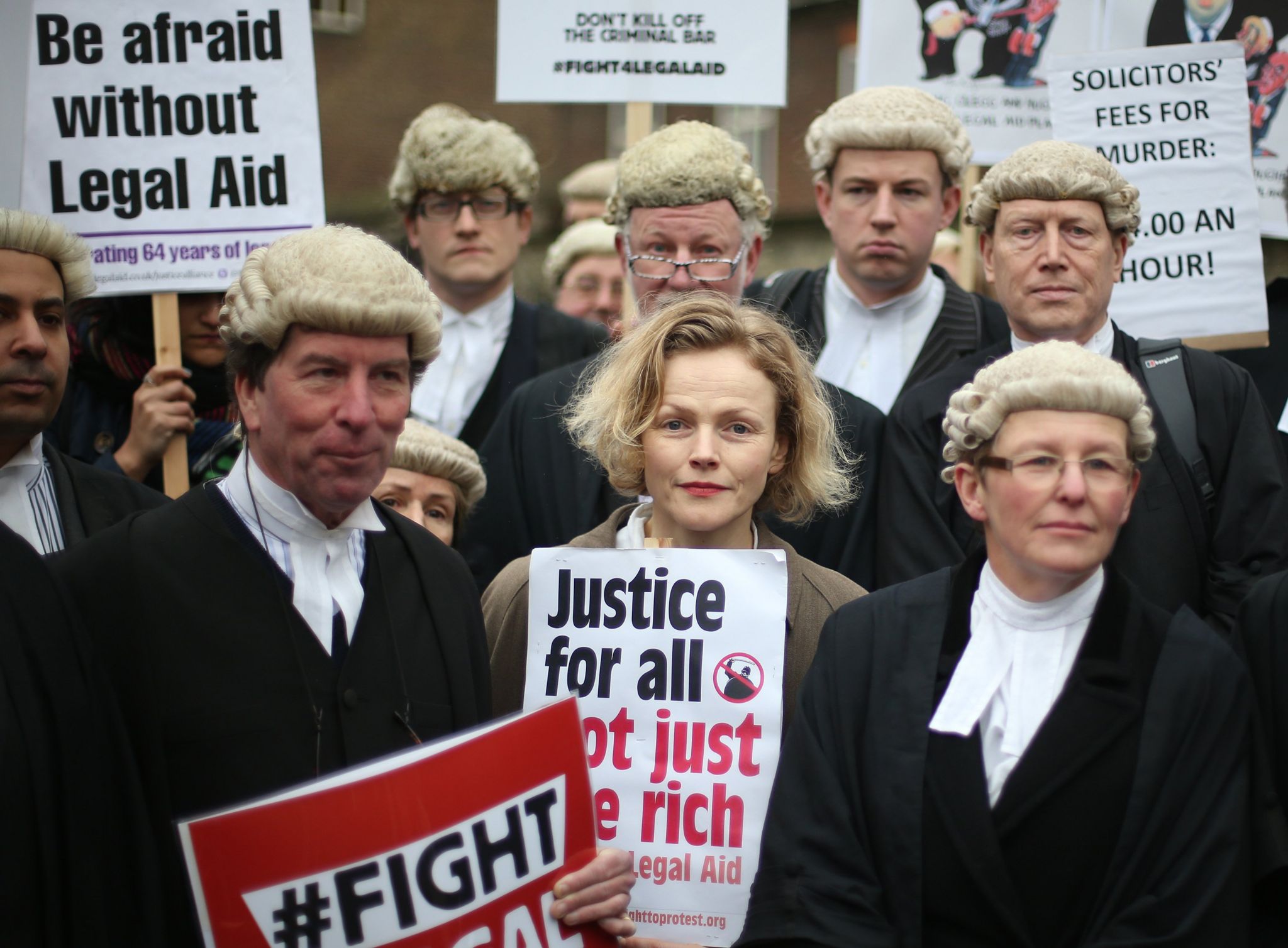legal aid protest actress maxine peake with barristers in wigs and gowns. sign reads justice for all, not just the rich