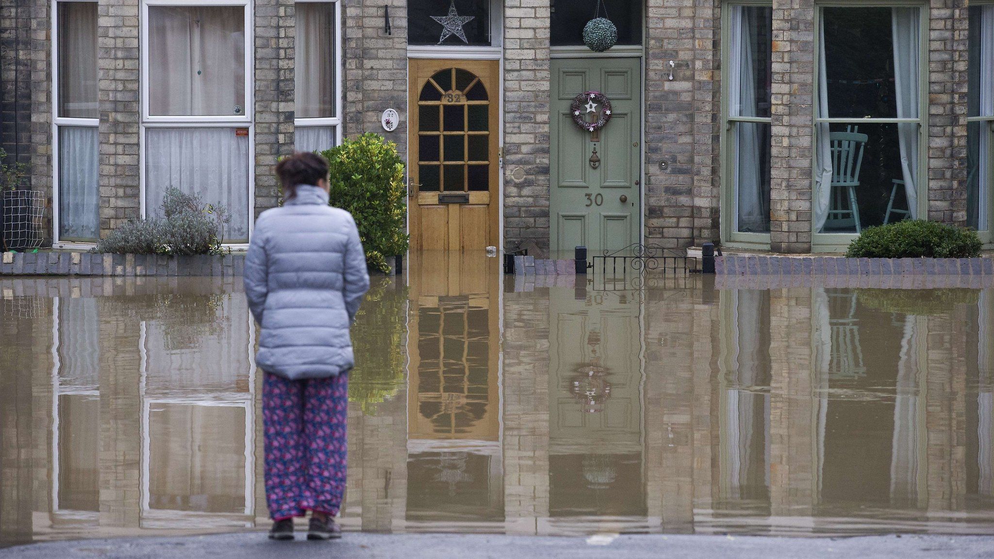 Woman looking at a flooded house