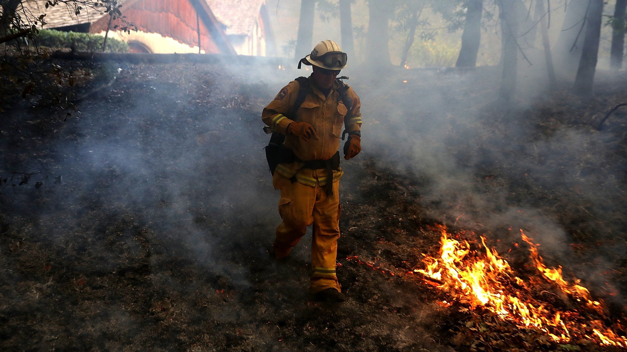 CalFire chief runs past burning grass during a firing operation while battling the Tubbs Fire on October 12, 2017 near Calistoga, California
