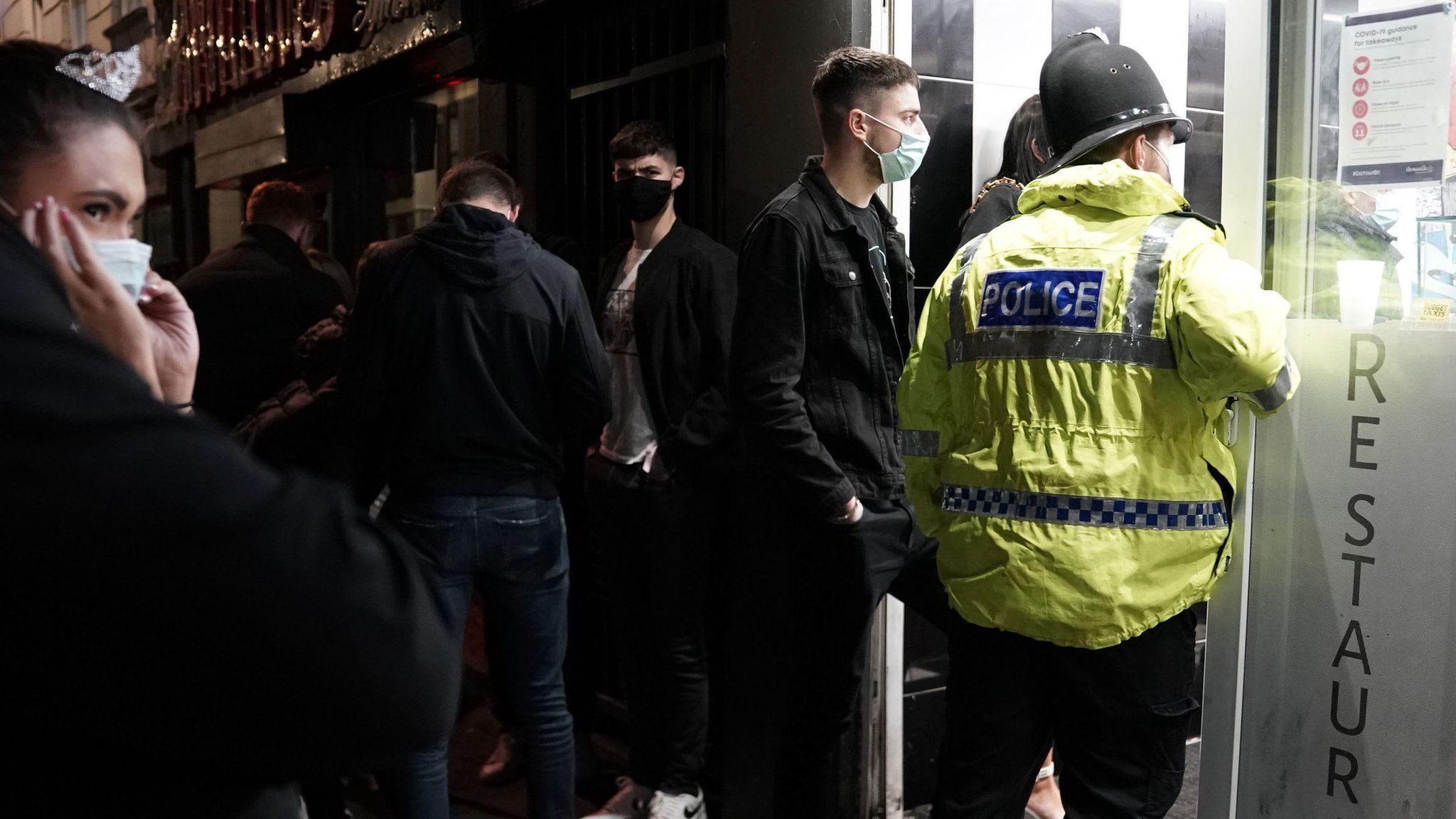 A police officer reminds workers in Newcastle city centre of the 10pm curfew that pubs and restaurants in England are subject to in order to combat the rise in coronavirus cases.