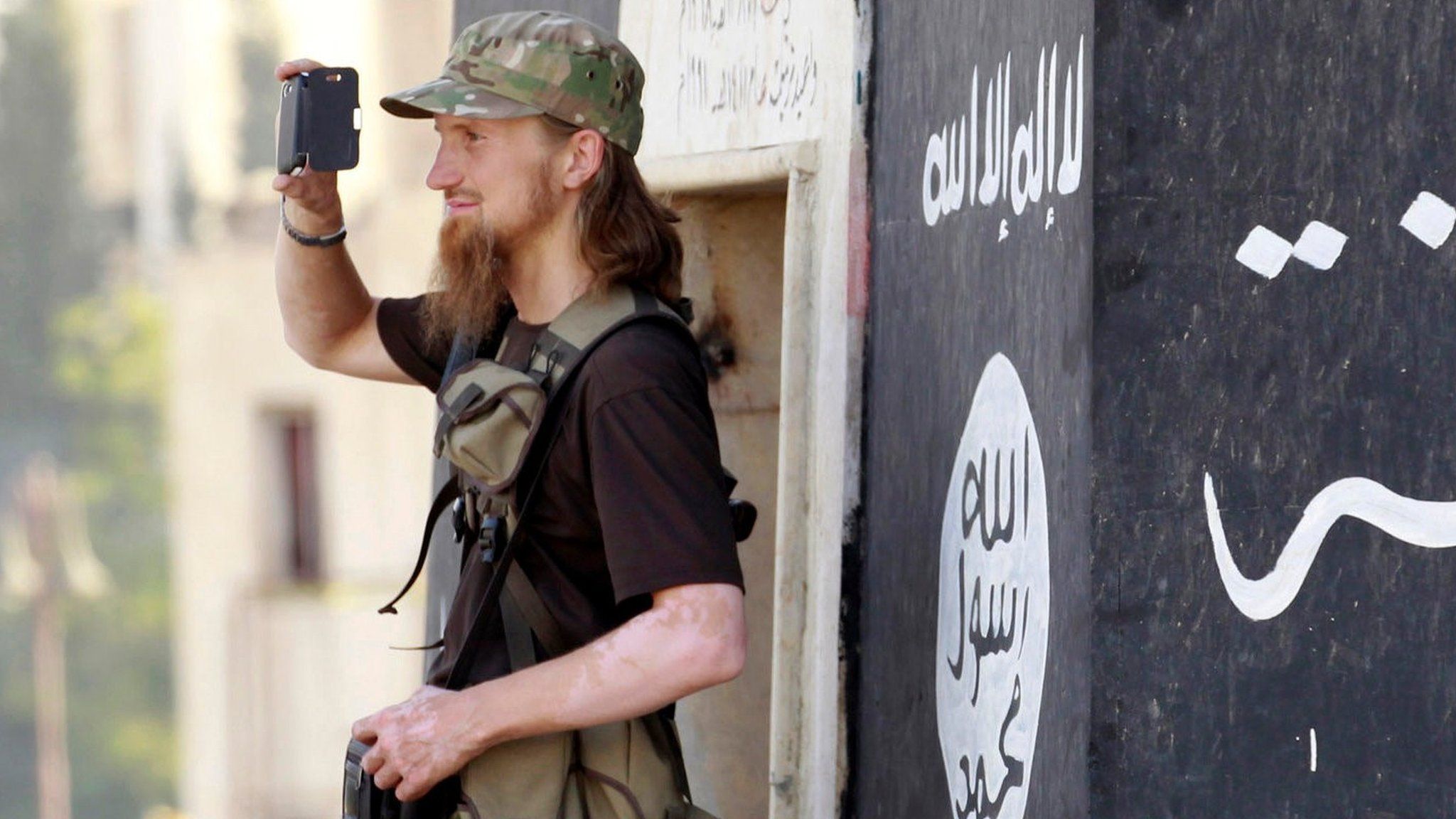 Jihadist takes a photo as IS militants celebrate in Raqqa on 30 June 2014