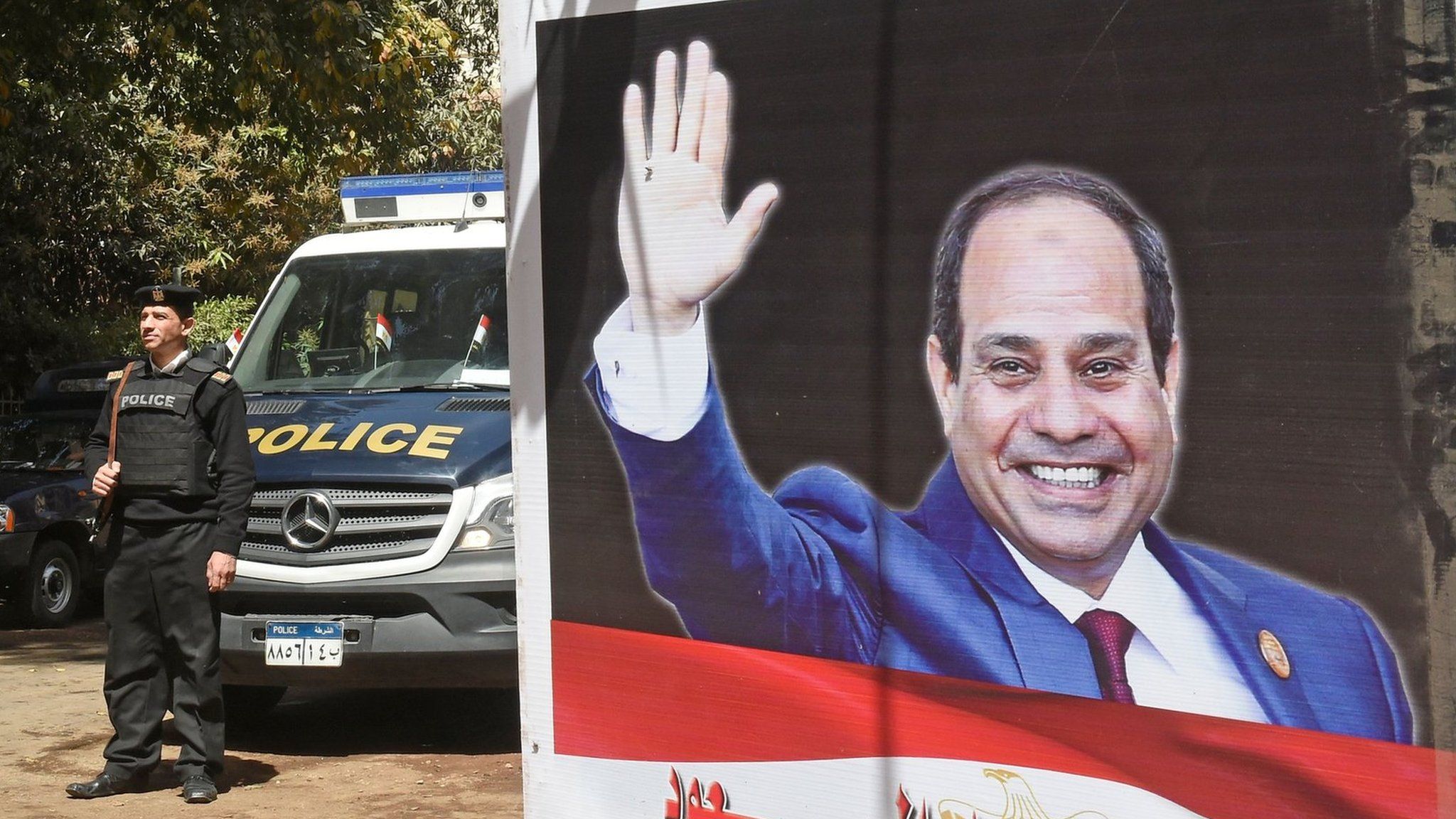 Egyptian policemen standing next to an electoral banner depicting President Abdel Fattah al-Sisi in the capital Cairo. March 26, 2018