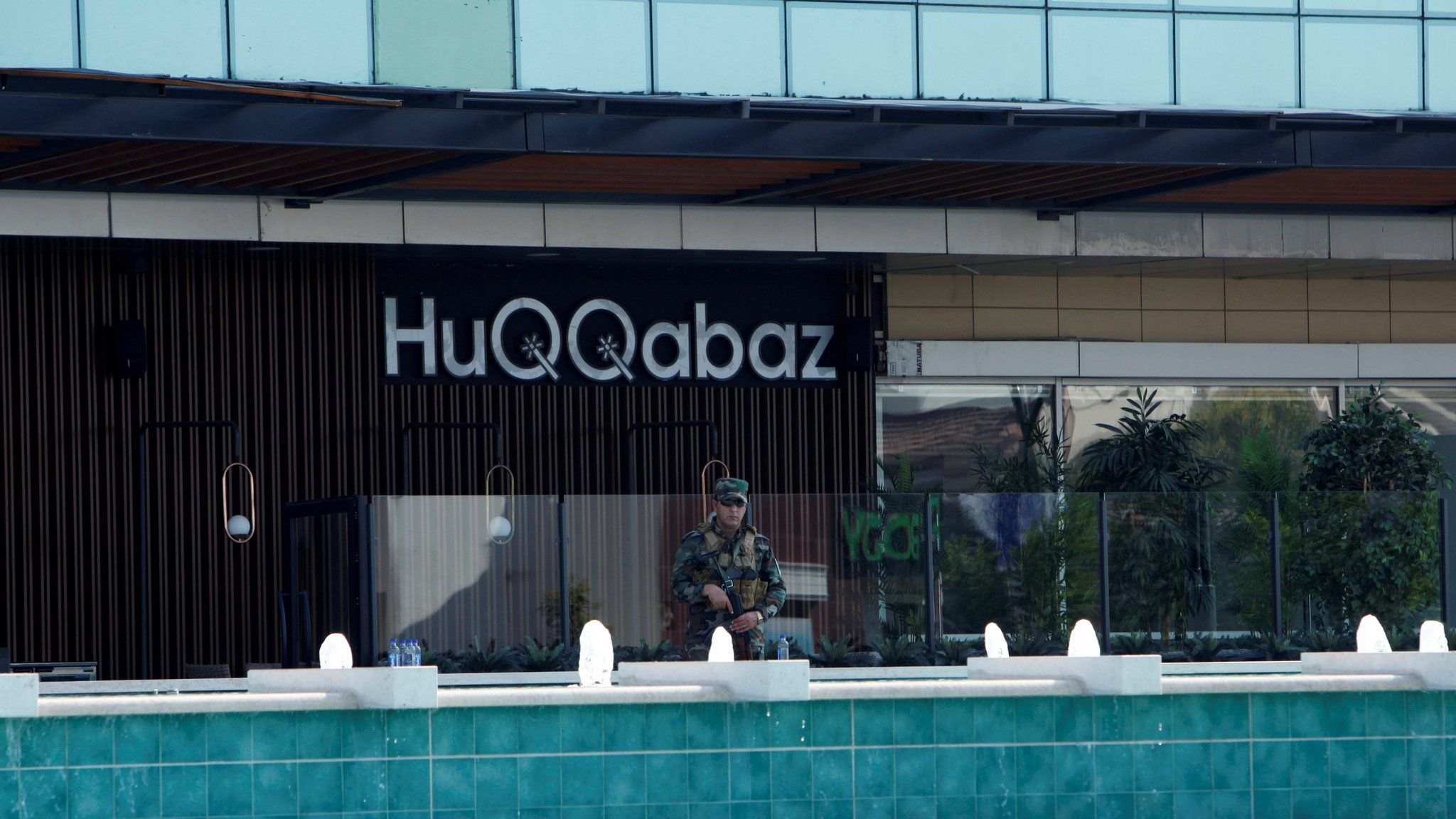 A Kurdish security member stands guard at a restaurant where the attack took place in Irbil