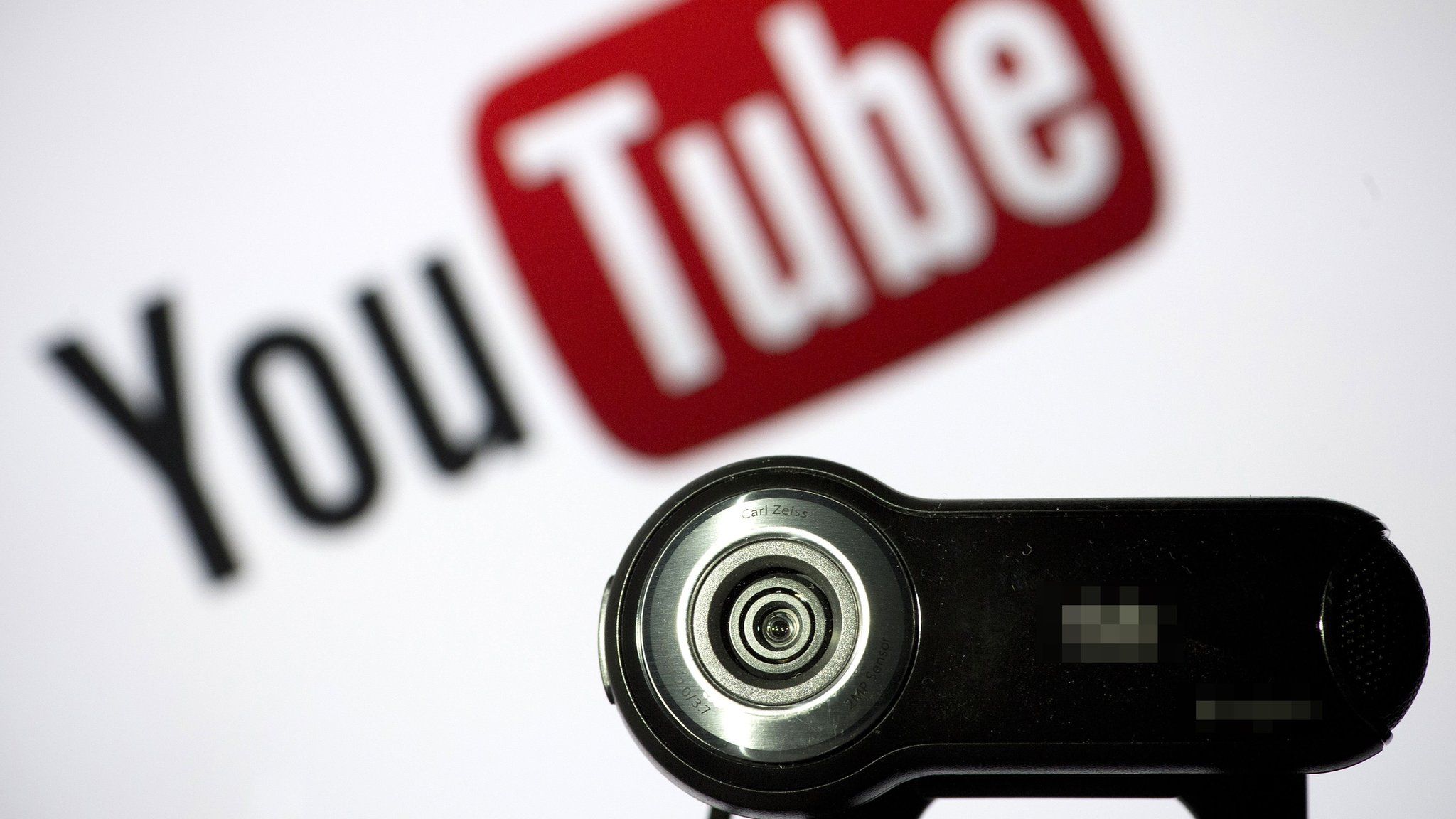 A webcam is positioned in front of a YouTube logo