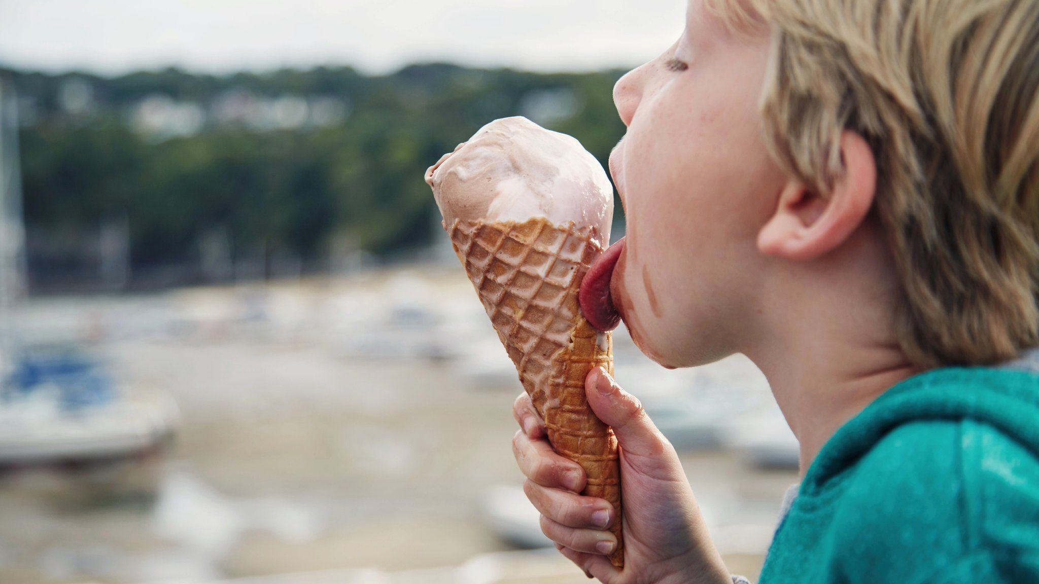 Boy eating an ice-cream on a Welsh beach