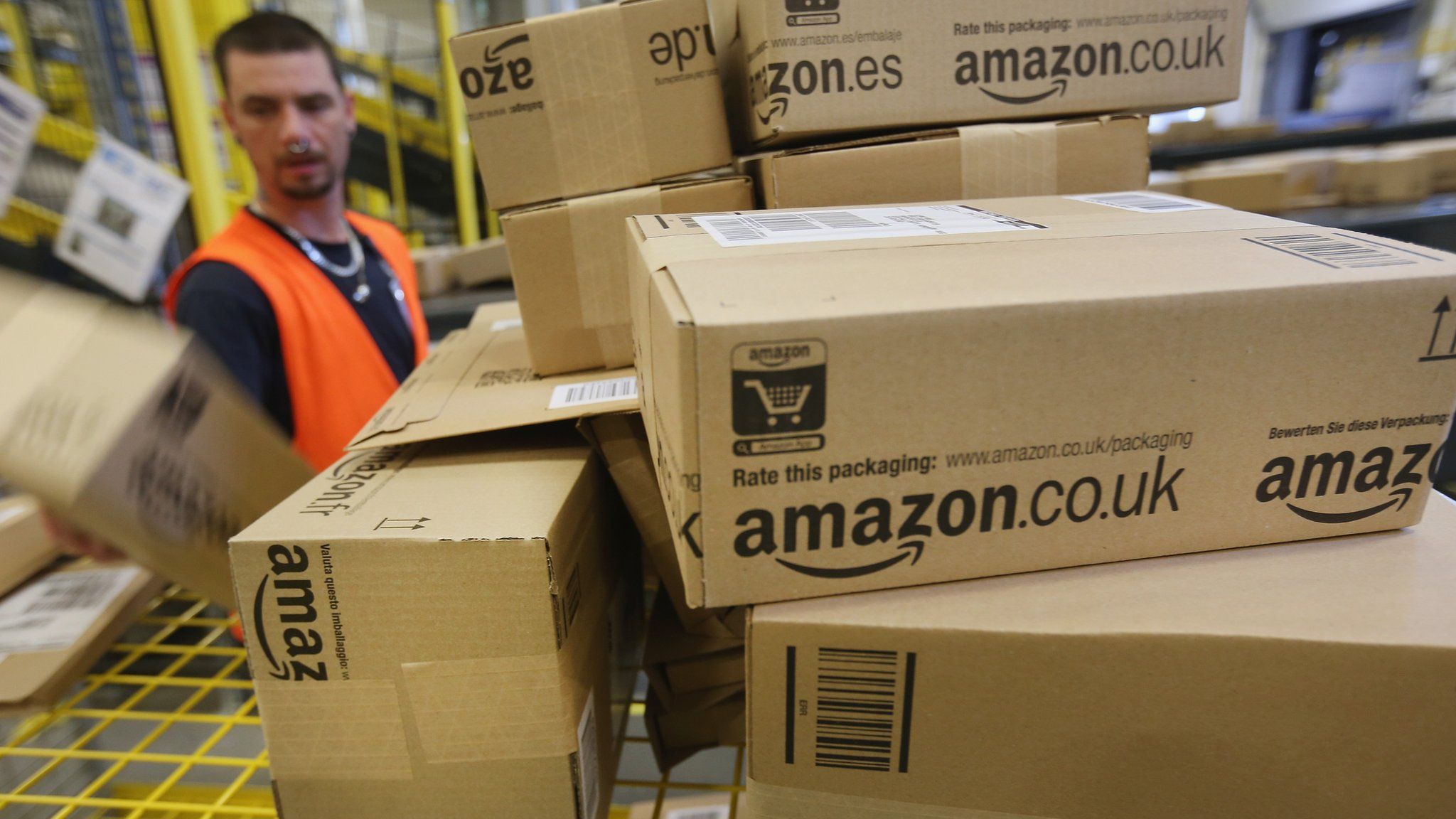 Amazon branded cardboard boxes being handled in one of the online retailers warehouses
