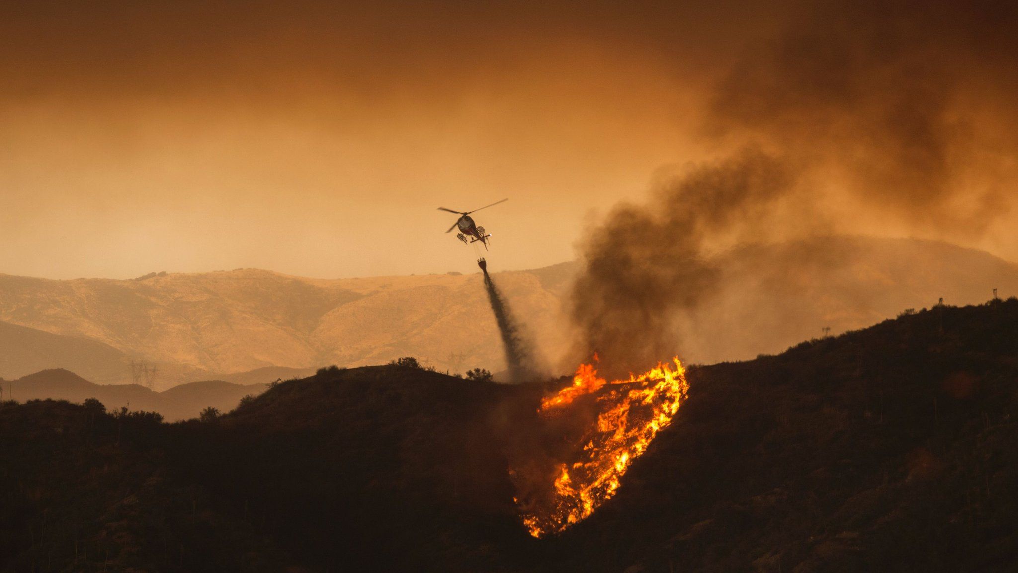 A firefighting helicopter drops water at the Sand Fire on July 23 2016 near Santa Clarita, California