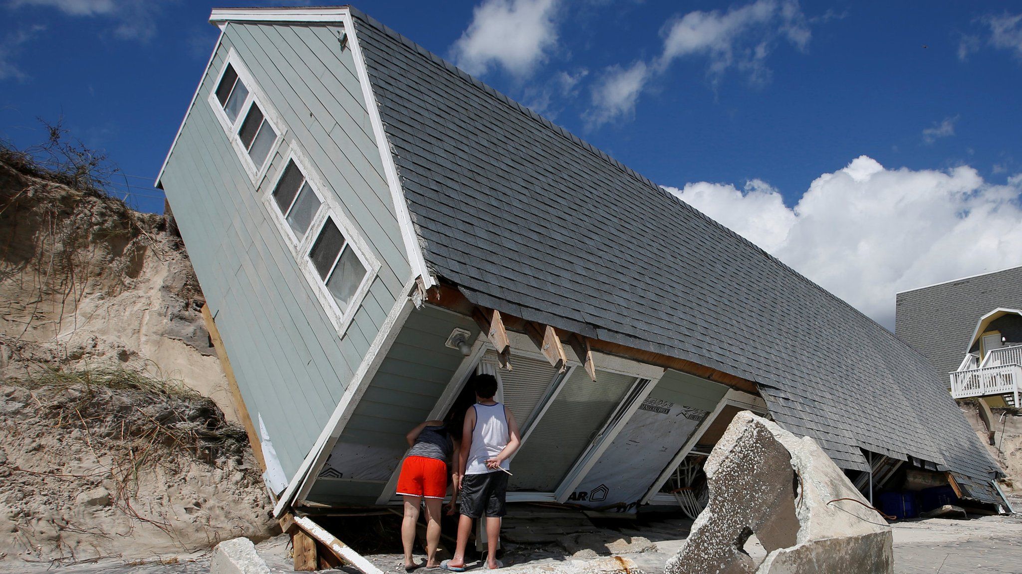 Local residents look inside a collapsed coastal house after Hurricane Irma passed the area in Vilano Beach, Florida