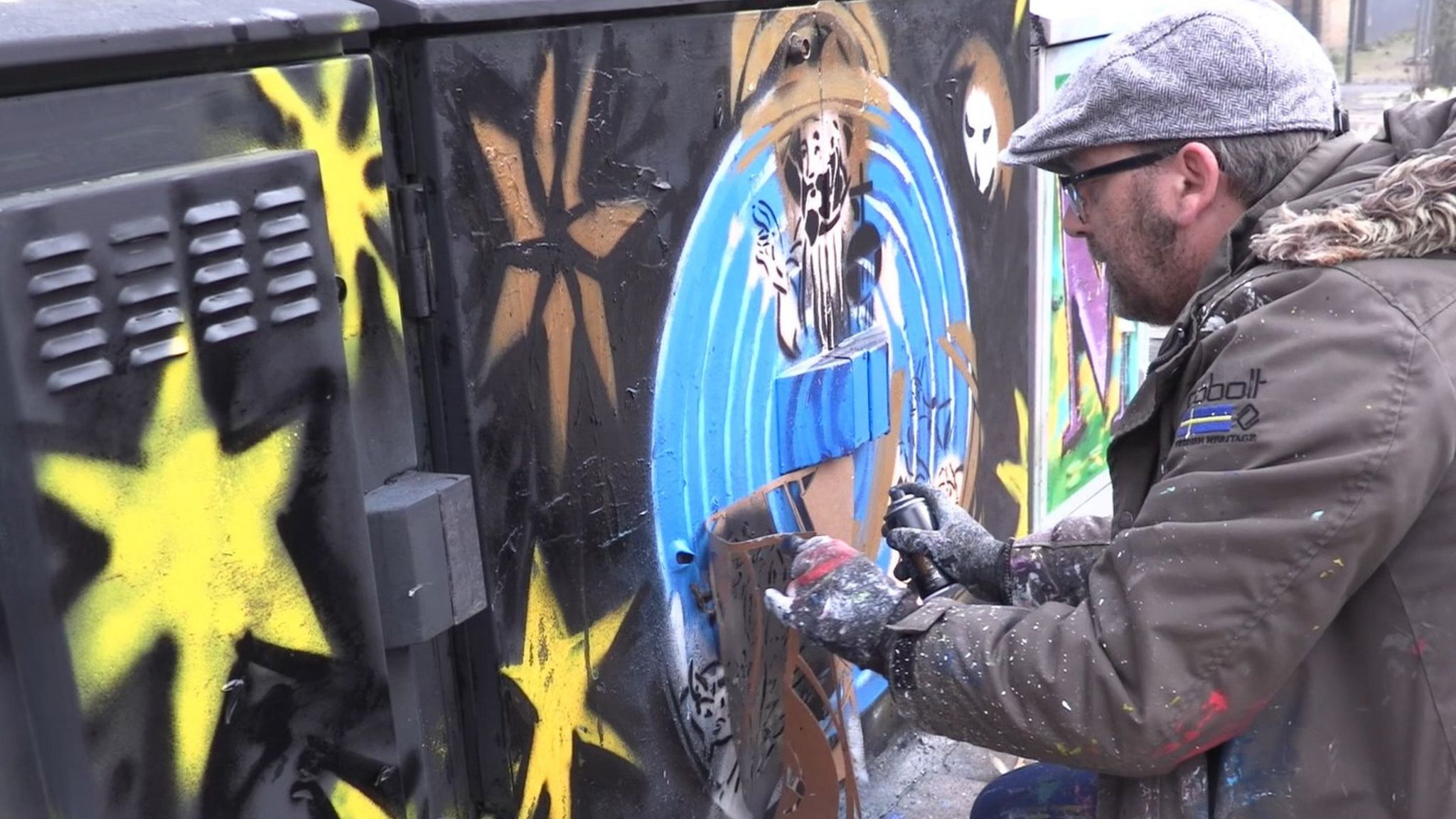 Artist spray painting an electrical box