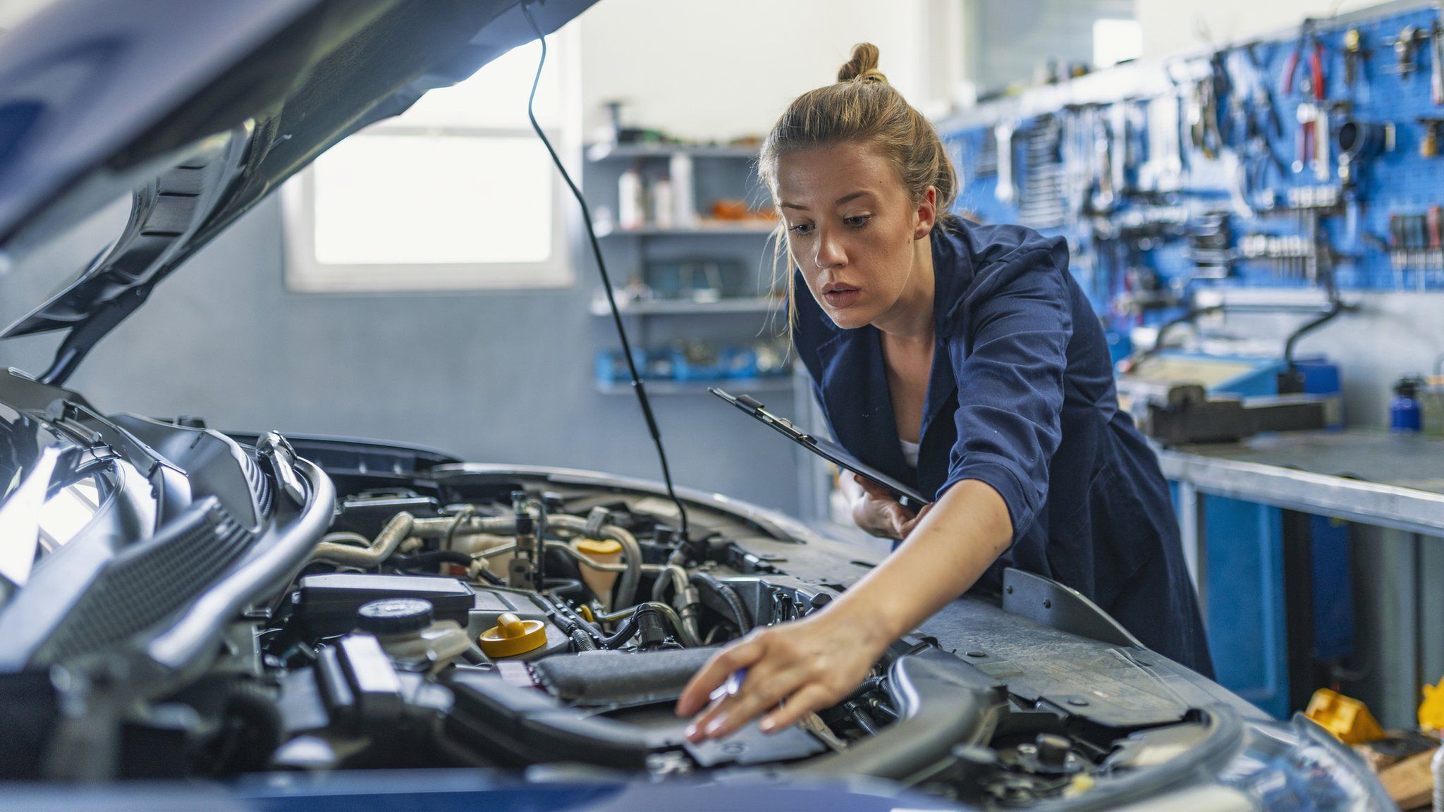 Woman looking at a car engine