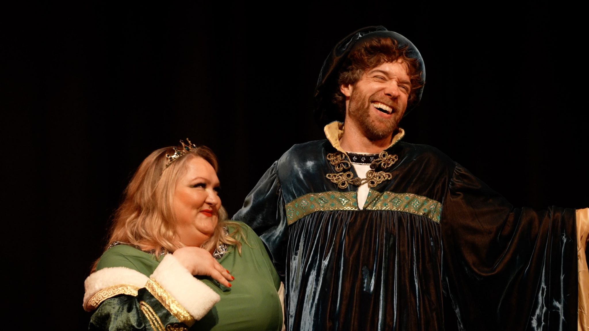 Actors playing a king and queen in a pantomime singing together