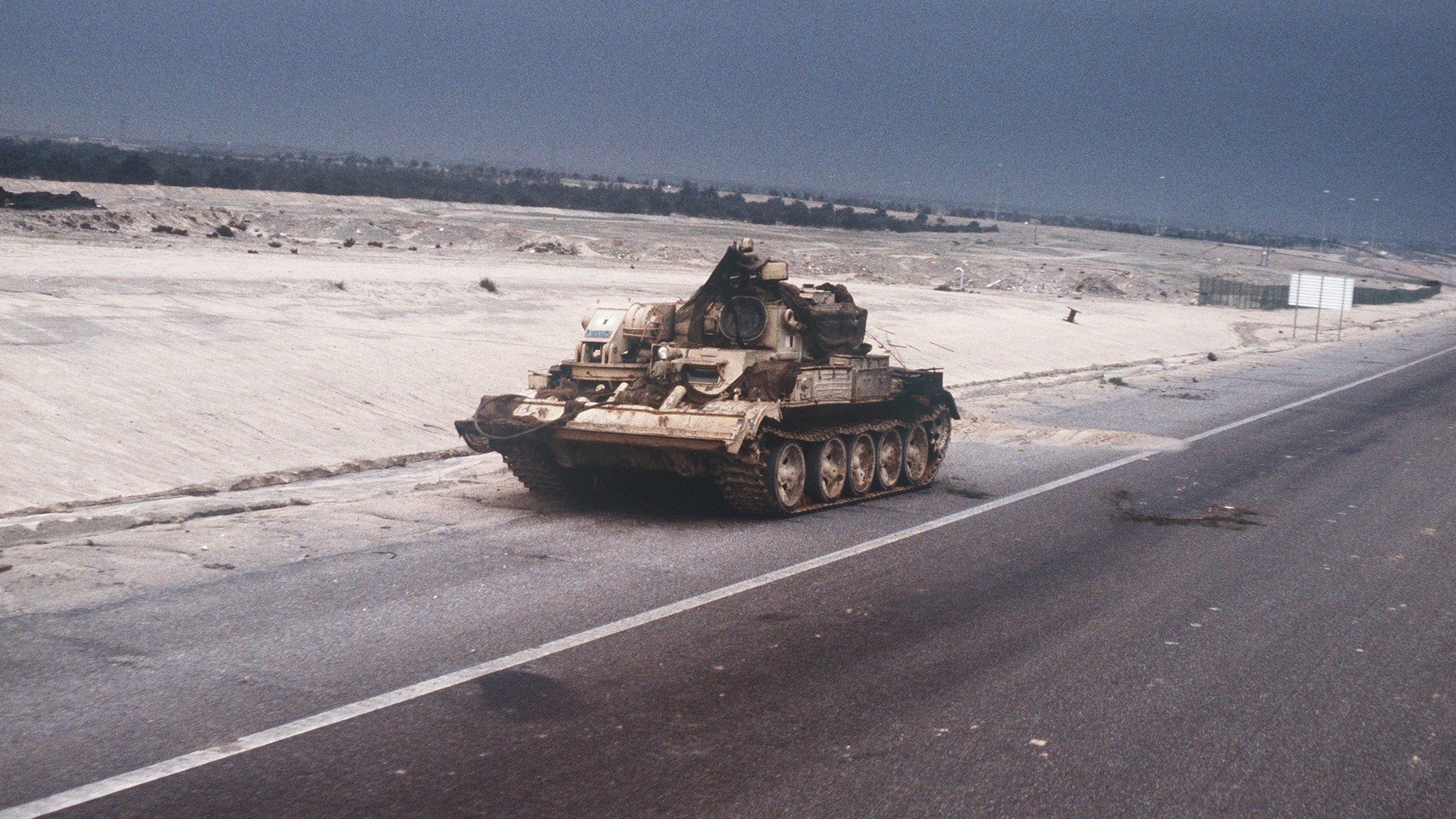 A Chinese-made Type 653 armored recovery vehicle abandoned by Iraqi troops sits on the side of the road into Kuwait City during the ground phase of Operation DESERT STORM.