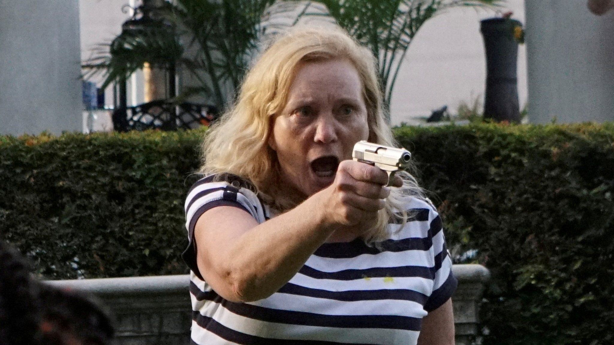 Patricia McCloskey aiming a handgun at protesters outside her home