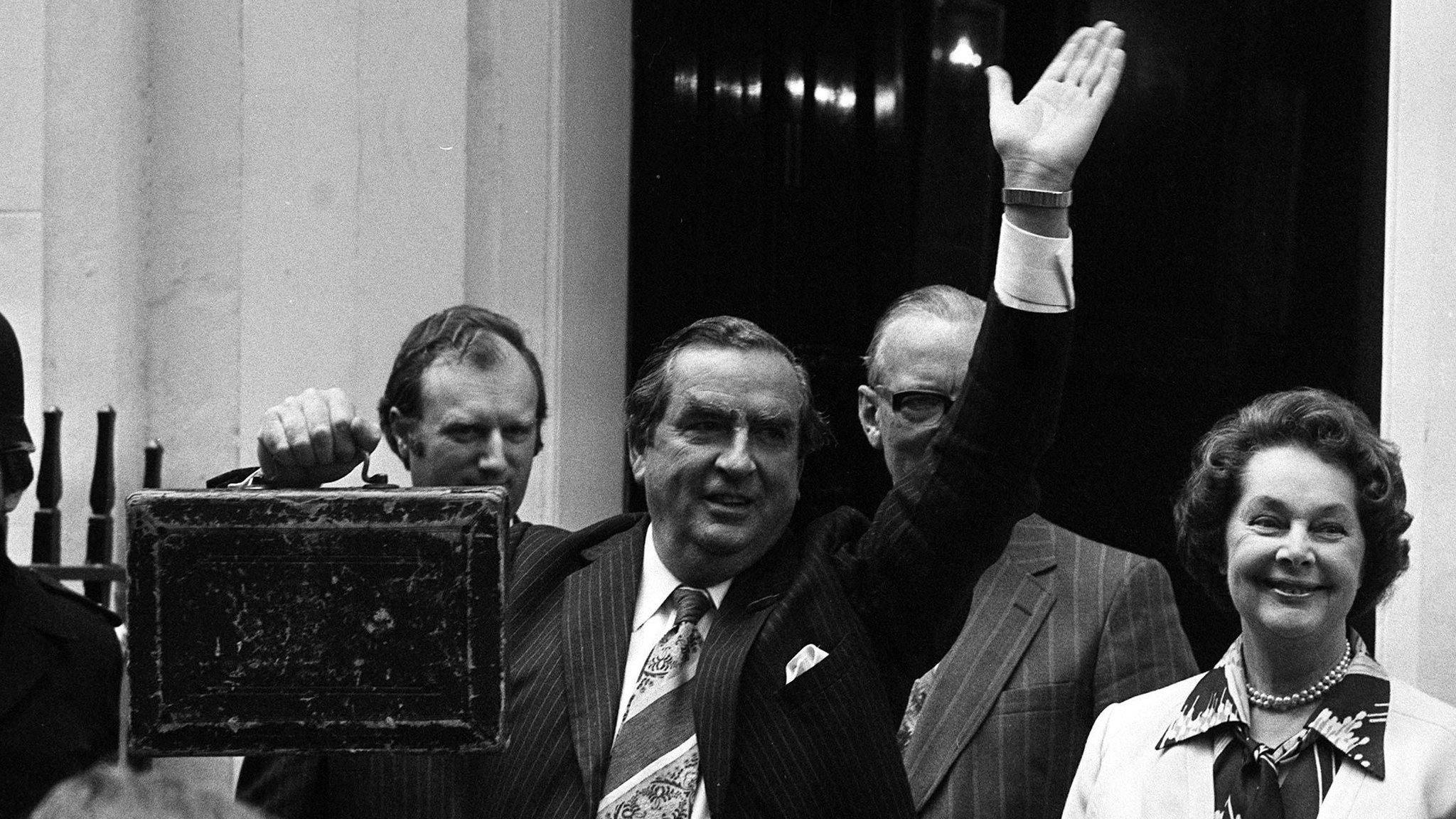 Chancellor of the Exchequer Denis Healey, holding the budget box and accompanied by his wife Edna, waves the crowd as they leave Number 11 (Eleven) Downing Street for the House of Commons where Mr Healey will present his budget