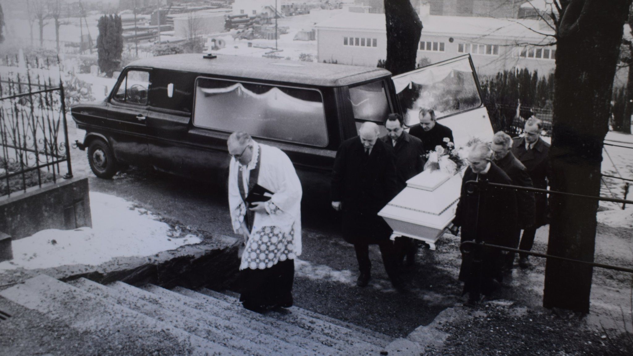 A police photo of the funeral shows a priest at Mollendal cemetery, while six police officers carry a white coffin containing the body of the Isdal Woman