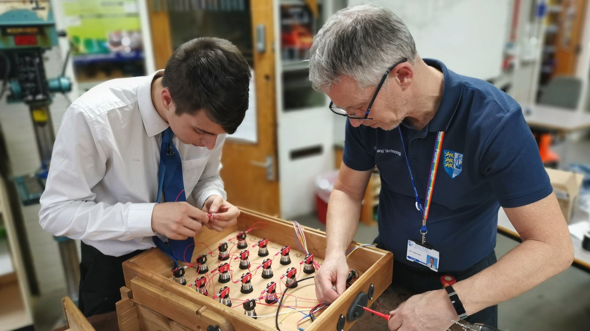 School pupil helping a REMAP engineer to build a games console for people with dementia.