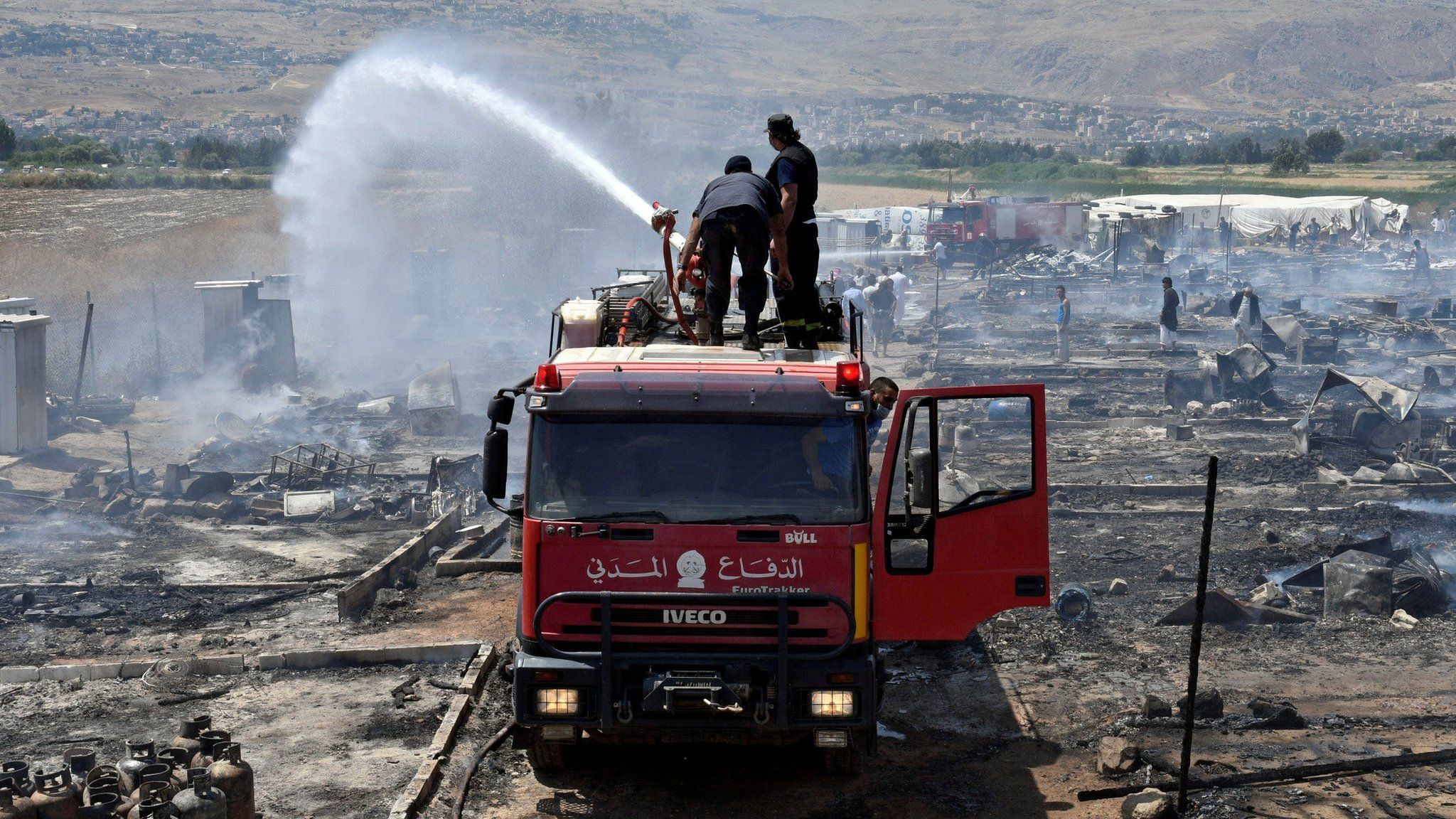 Firefighters put out fire at refugee camp in Lebanon on 2 July 2017