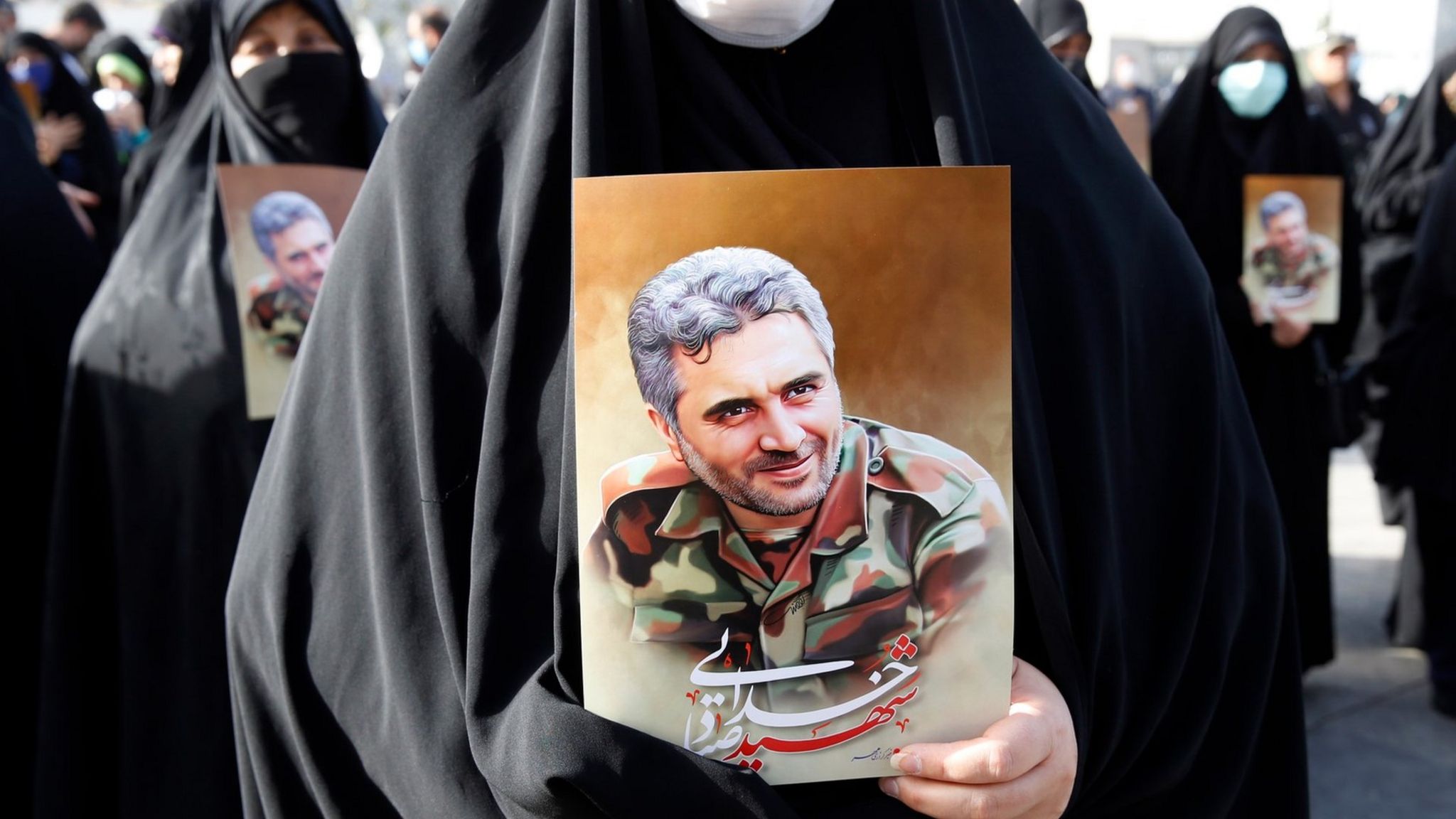 An Iranian woman carries a poster showing Revolutionary Guards Colonel Sayad Khodai at his funeral in Tehran, Iran (24 May 2022)