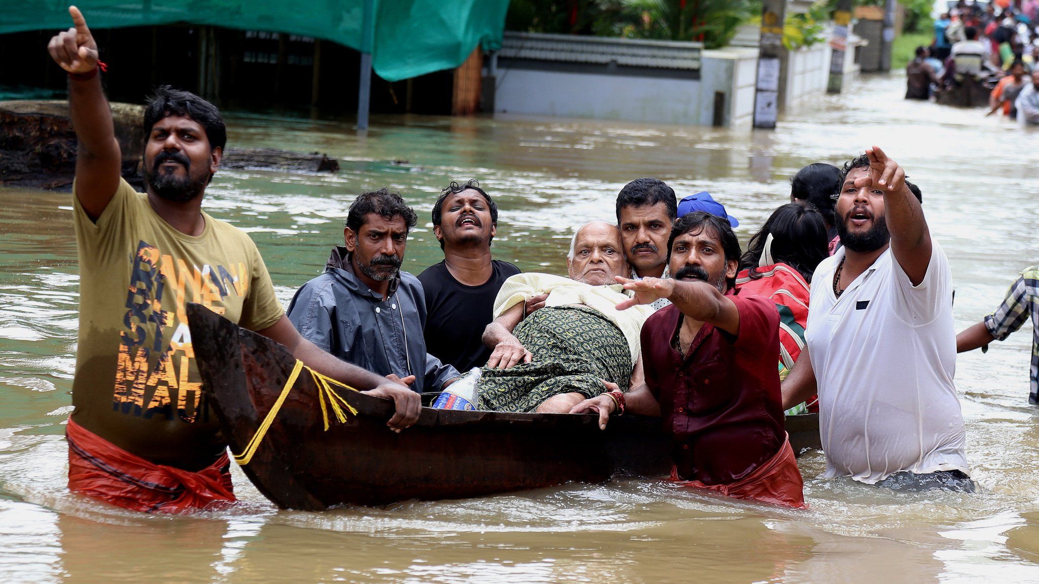 Indian people use a boat to rescue an elderly man in the flooded water in Kochi, Kerala state, India, 17 August 2018
