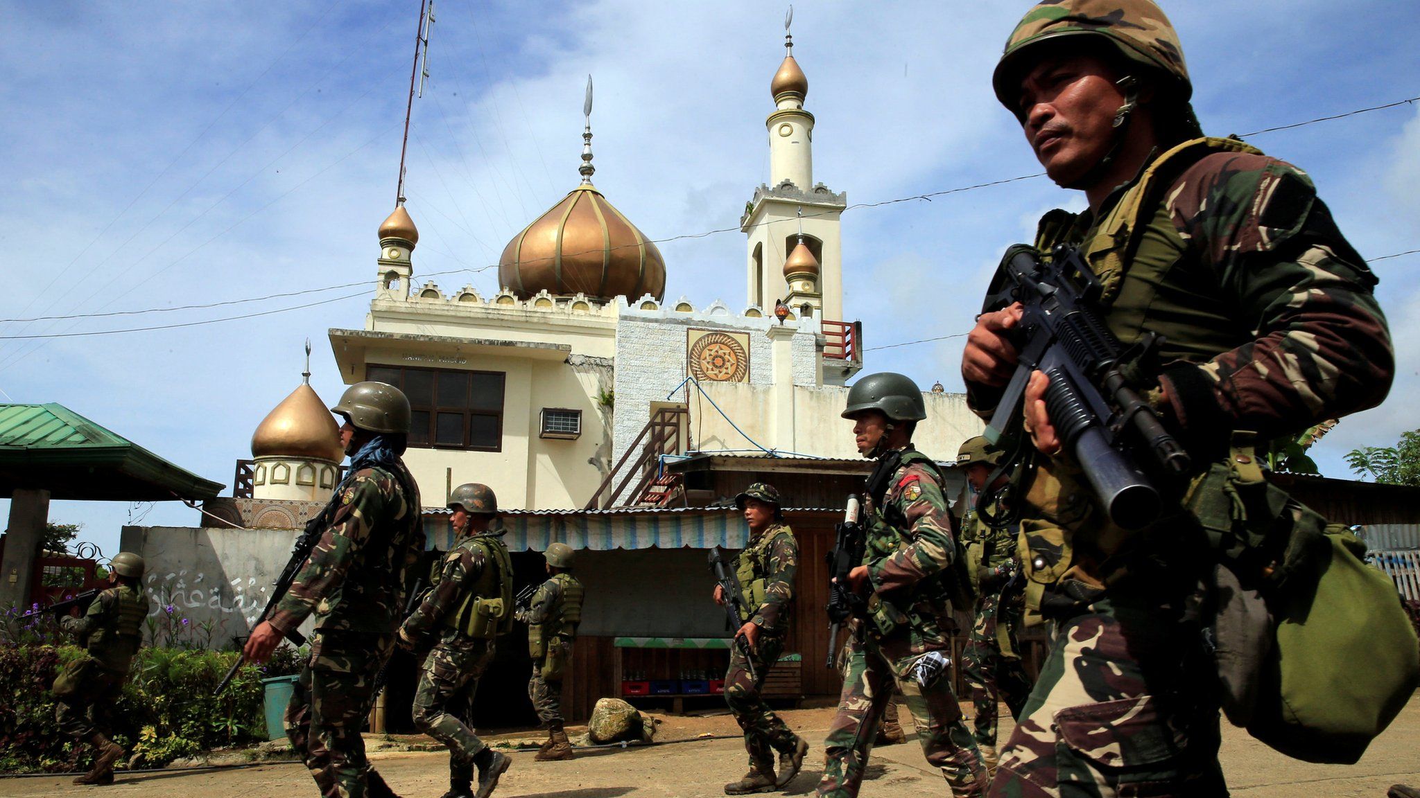 Government troops walk past a mosque before their assault with insurgents from the so-called Maute group, who have taken over large parts of Marawi City, southern Philippines 25 May 2017