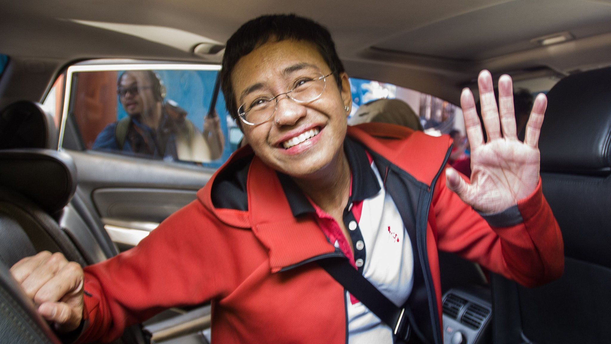 Philippine journalist Maria Ressa waves to photographers after posting bail outside a court building in Manila in March 2019