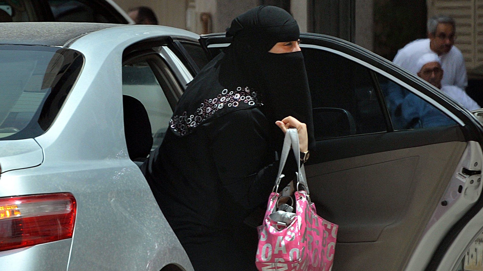 A Saudi woman gets out of a car after being given a ride by her driver in Riyadh on 26 May, 2011