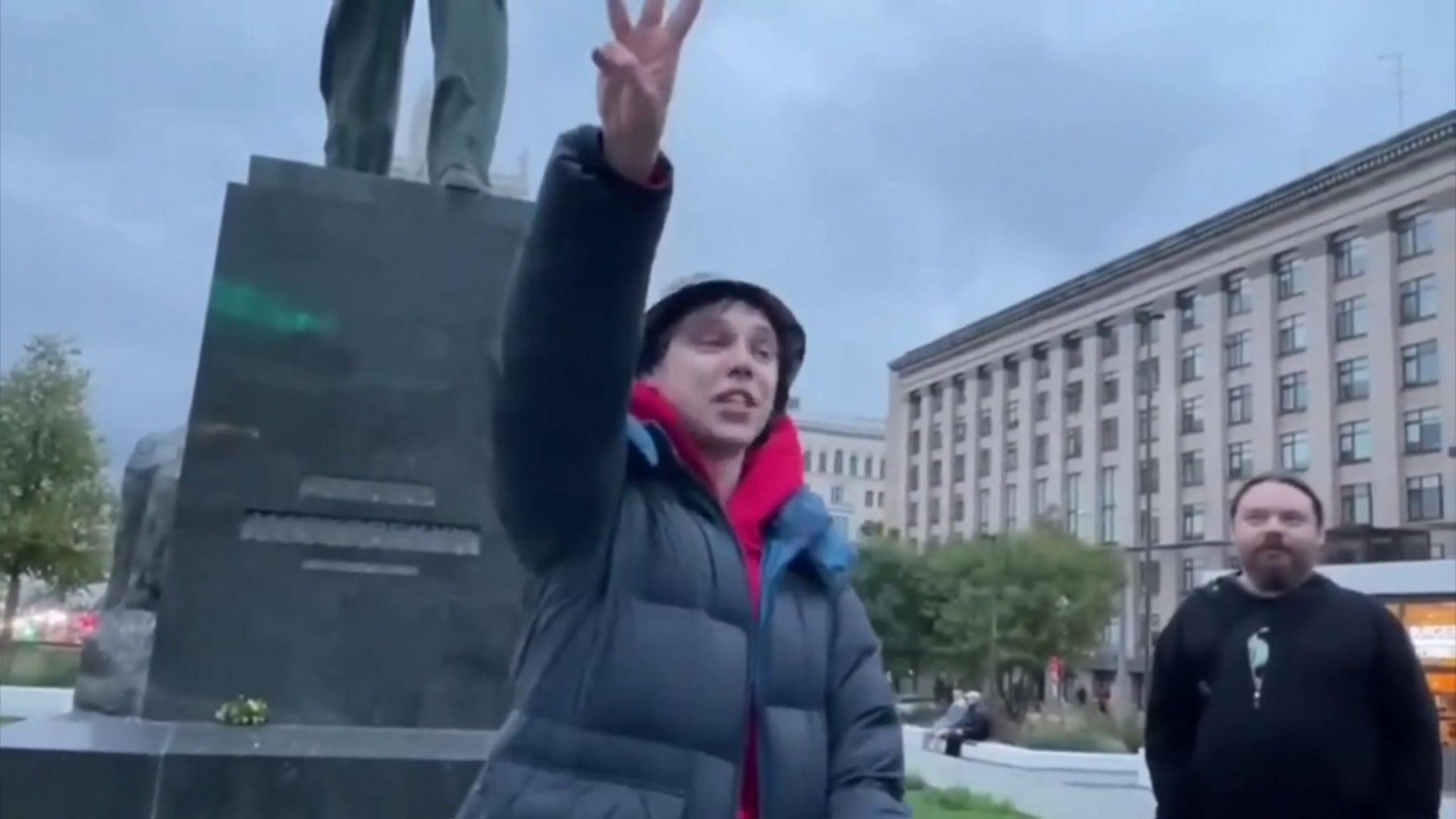 Artyom Kamardin holds up the peace sign in Triumfalnaya Square on an overcast Moscow day