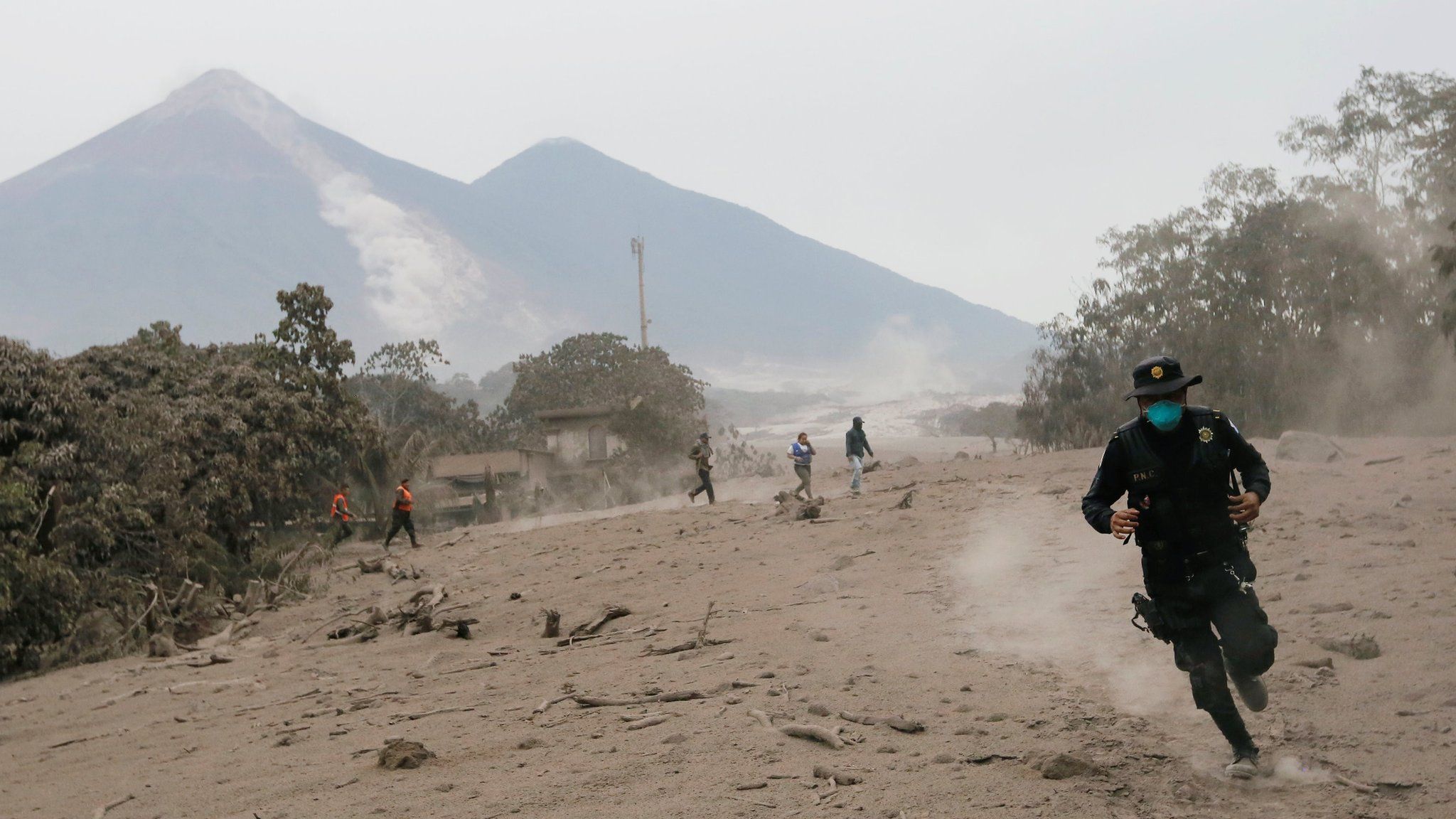 A police officer runs away from a new pyroclastic flow spewed by the Fuego volcano in the community of San Miguel Los Lotes in Escuintla, Guatemala, June 4, 2018