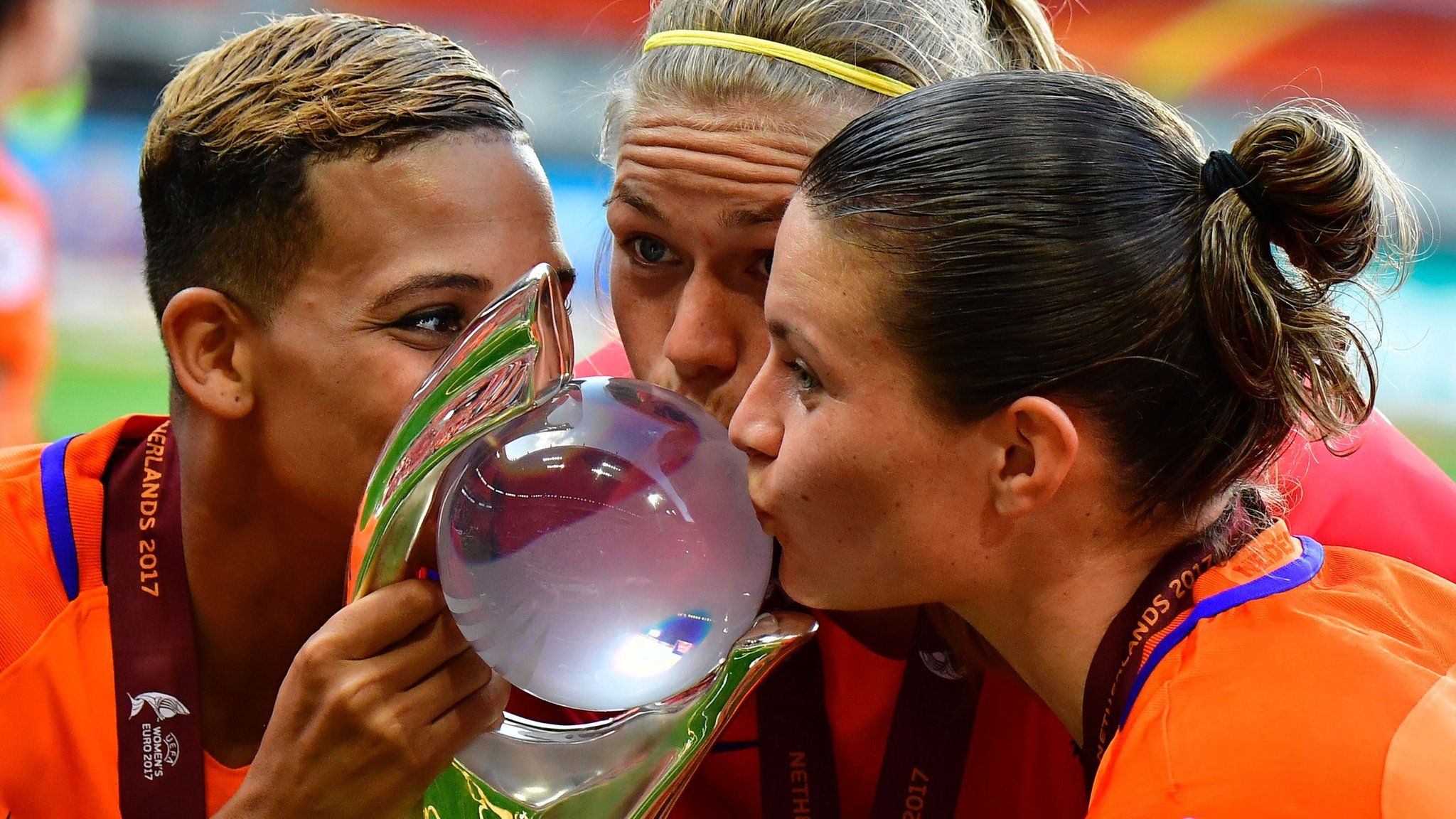 Netherlands' forward Shanice van de Sanden, Netherlands' defender Anouk Dekker and Netherlands' midfielder Sherida Spitse kiss the European trophy after winning it in 2017