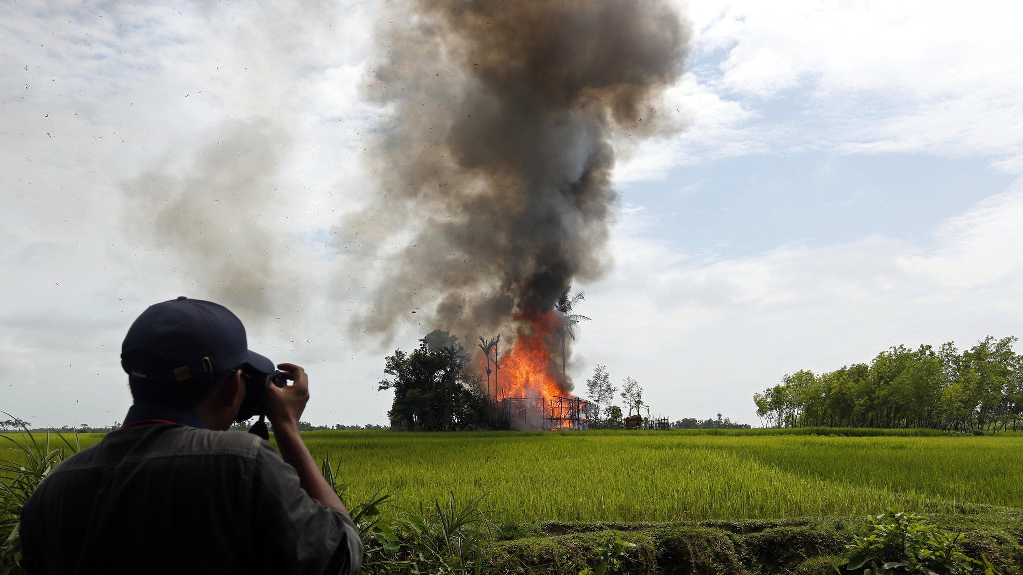 Journalist take photos of a burning house at the Gawdu Zara village in Maungdaw township, Rakhine State, western Myanmar, 7 September 2017