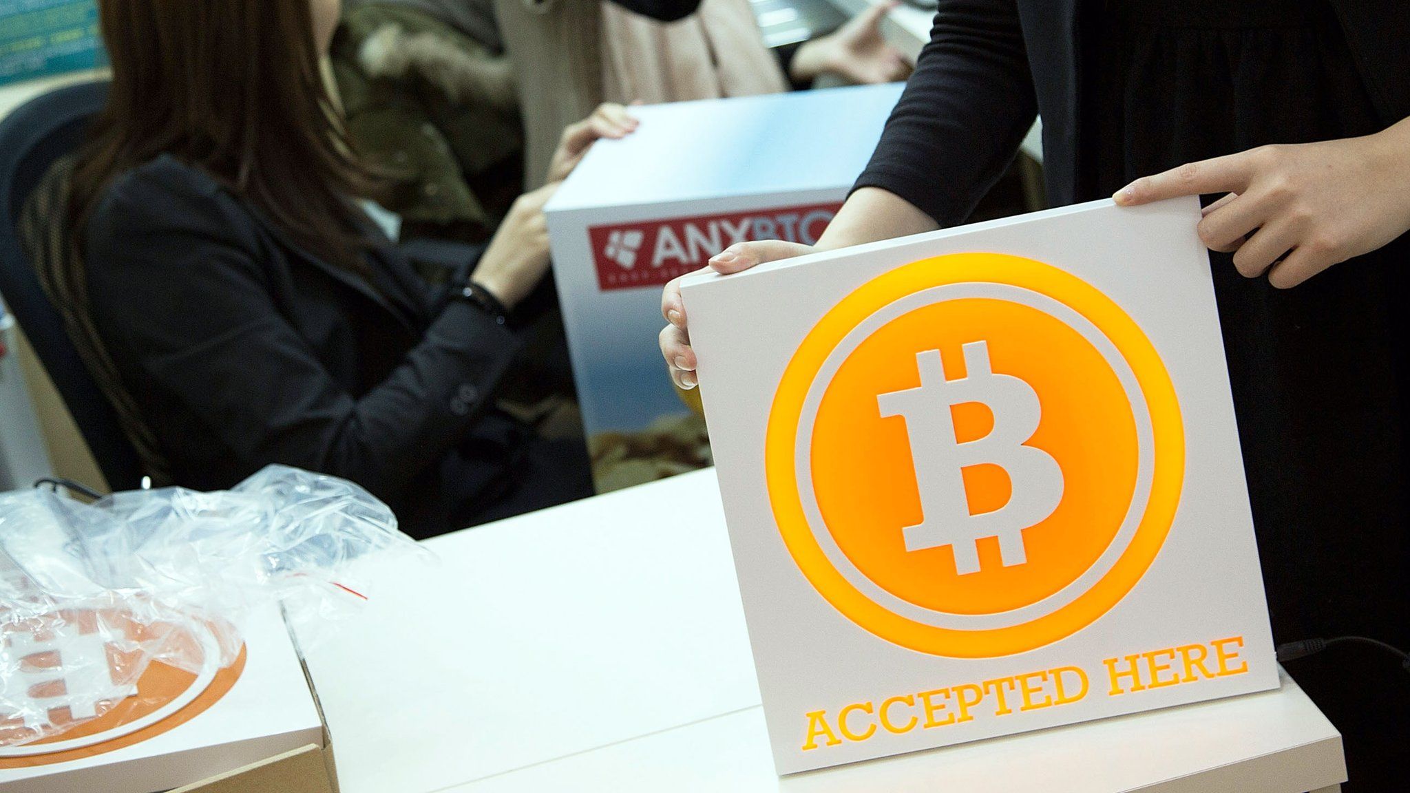 A worker holds a sign at the first Bitcoin store in Hong Kong