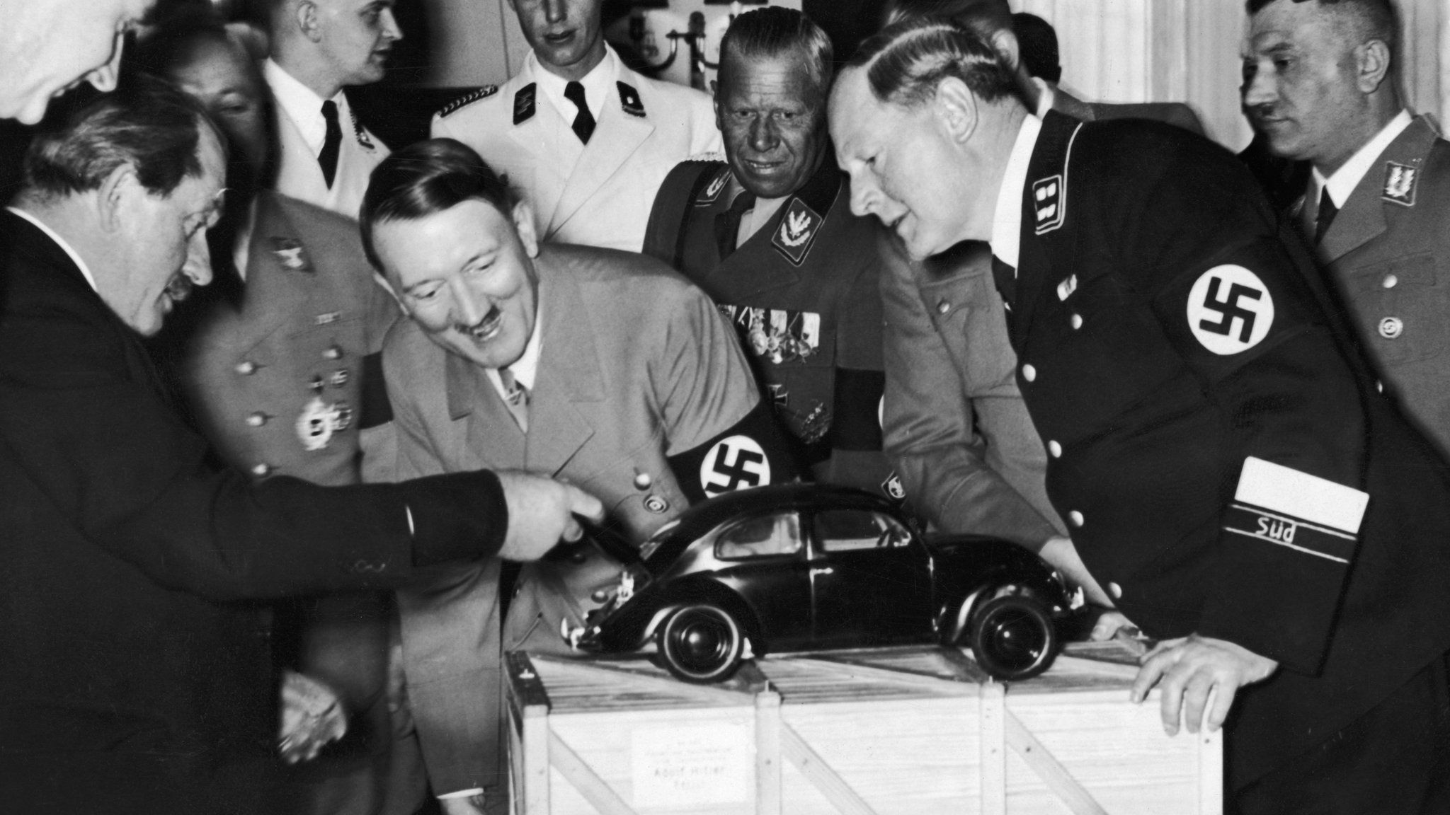 Adolf Hitler looks at a model of the Volkswagen car. He is with the designer Ferdinand Porsche (left)