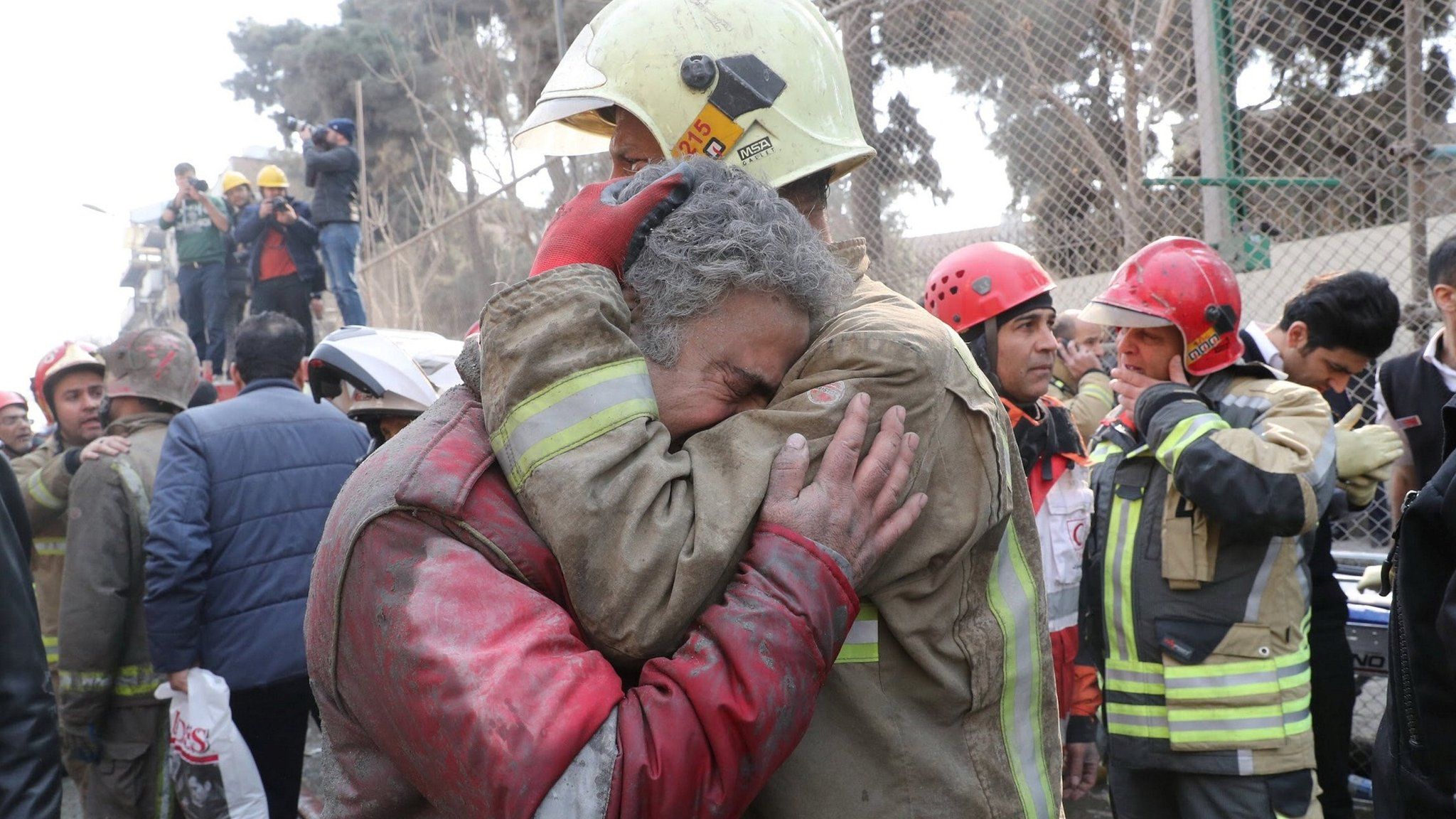 Firefighters react at the site of a collapsed high-rise building in Tehran, Iran (19 January 2017)