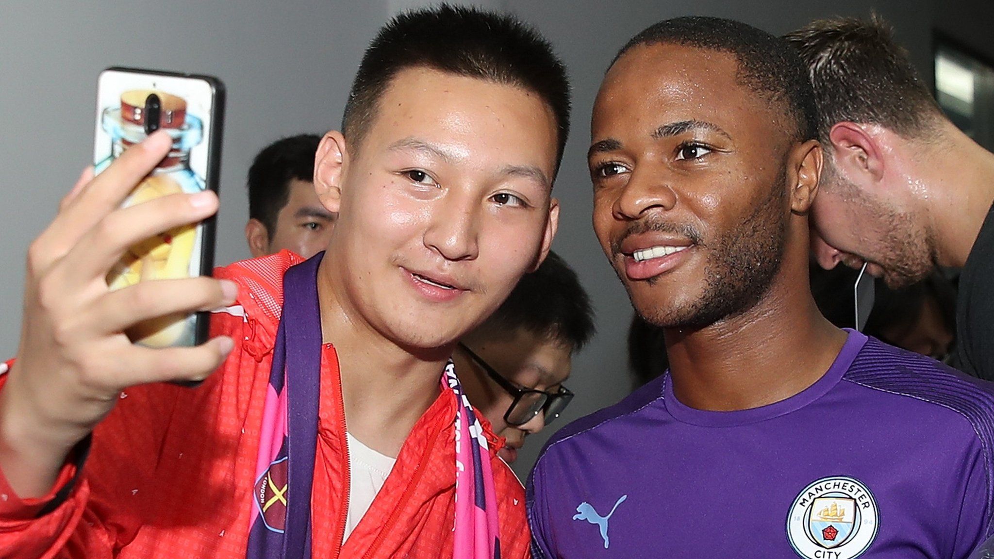 Raheem Sterling poses for a selfie with a fan in China