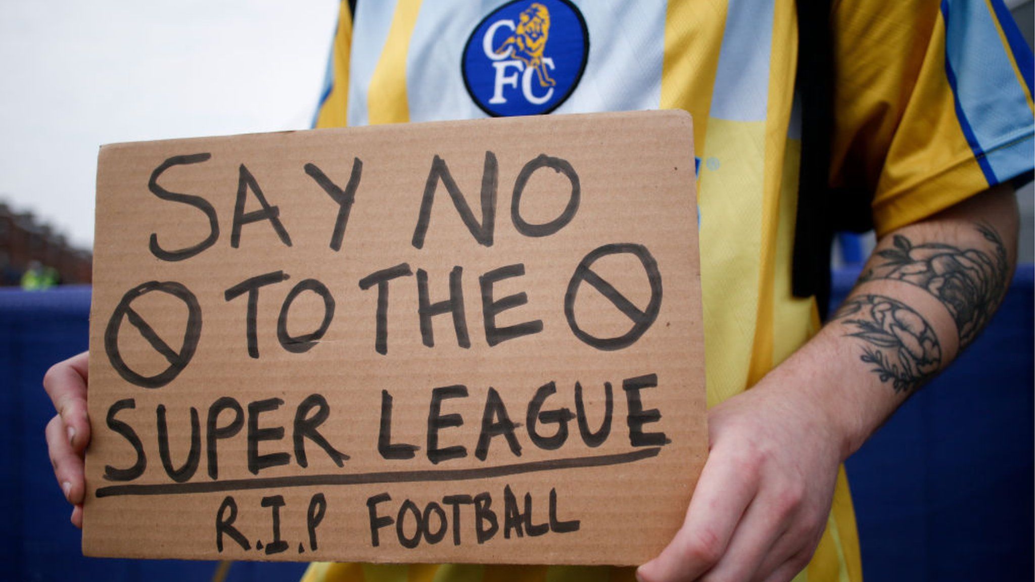 A fan holds up a sign in protest against the European Super League
