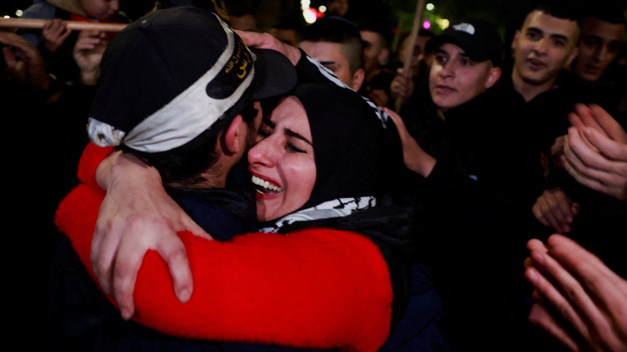 A Palestinian mother cries as she hugs her returned son