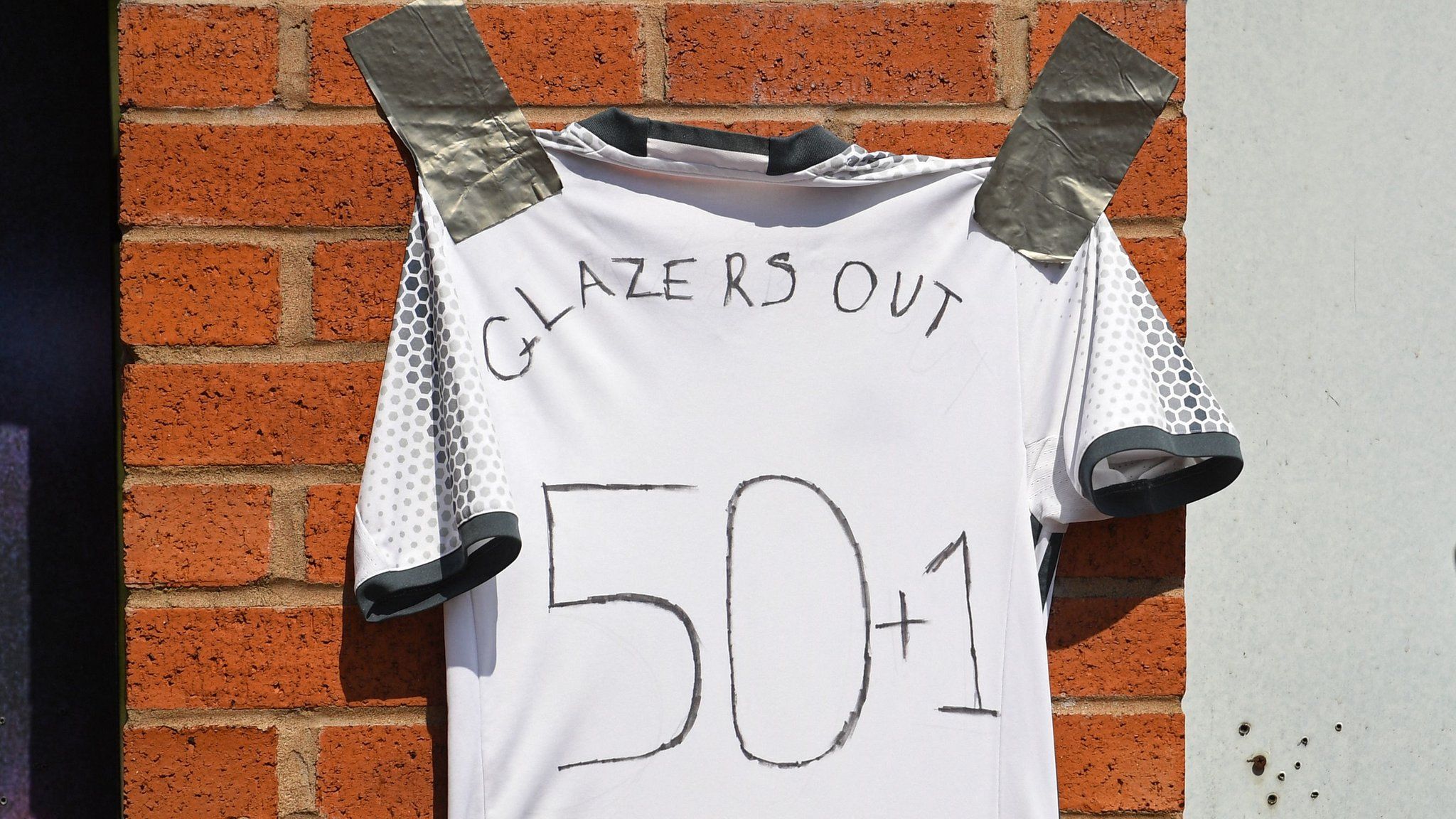 'Glazers Out' written on a shirt outside Old Trafford