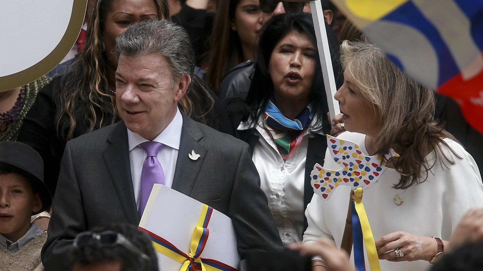 Colombian President Juan Manuel Santos carries a copy of the final text peace agreement with Farc on 25 August 2016