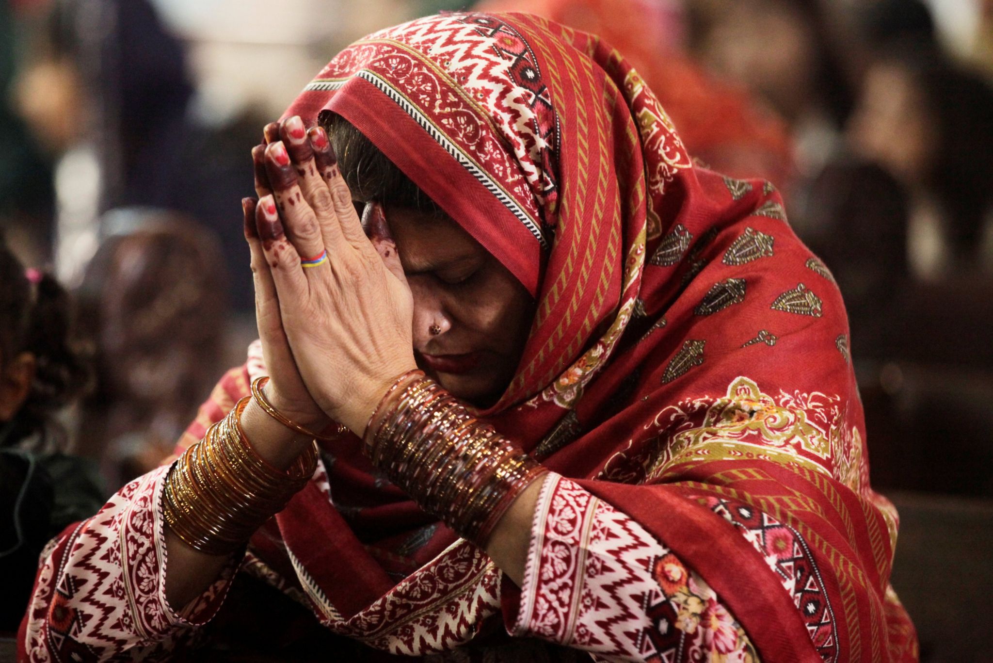 A woman prays during a Christmas service at the Sacred Heart Cathedral in Lahor