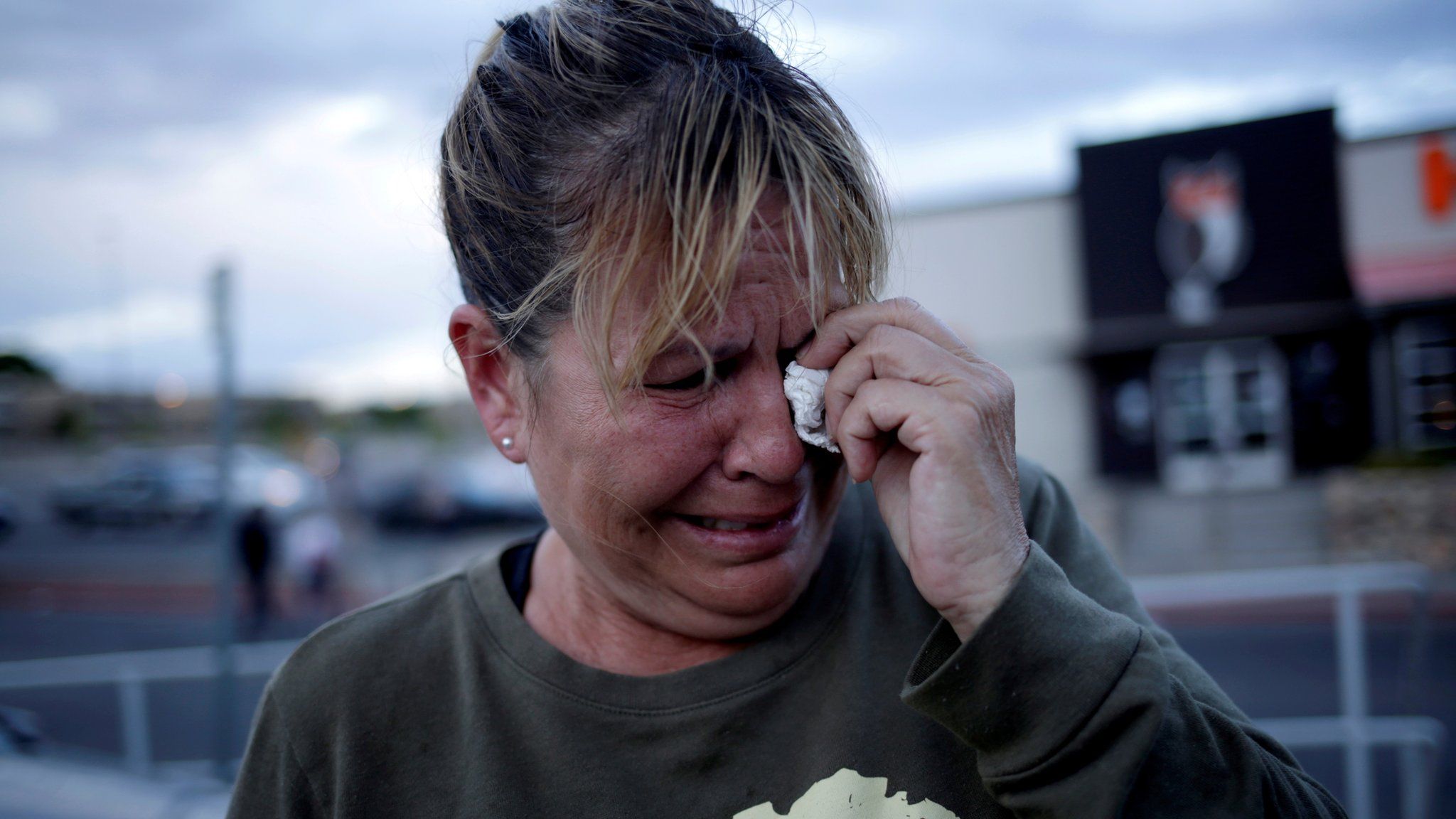 A woman reacts after a mass shooting at a Walmart in El Paso