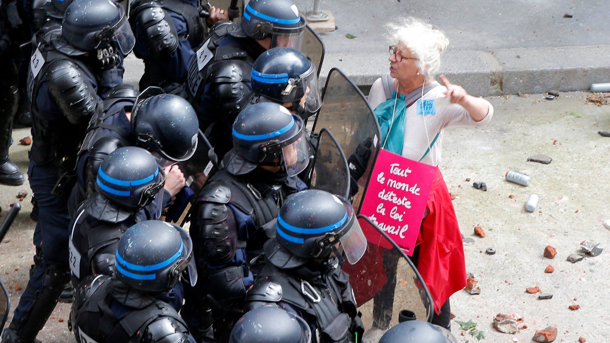 A woman, with a poster reading "We all hate the Labor Law", argues with riot police officers during a demonstration in Paris Tuesday, 14 June 2016