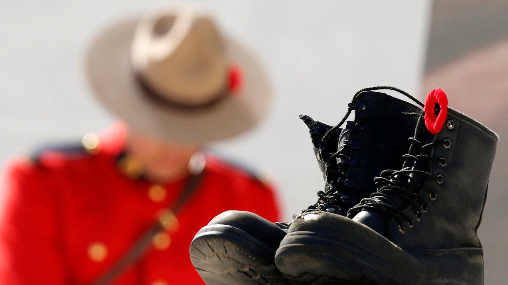 A Mountie bows his head behind a pair of empty boots to symbolise fallen soldiers at the battle of Vimy Ridge (9 April)