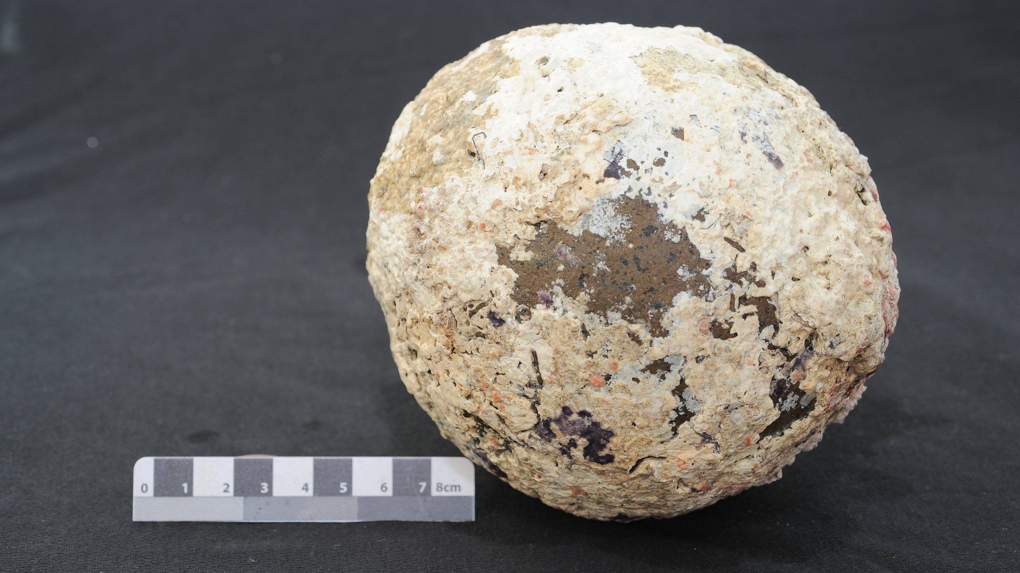 Photo of the cannonball beside a ruler
